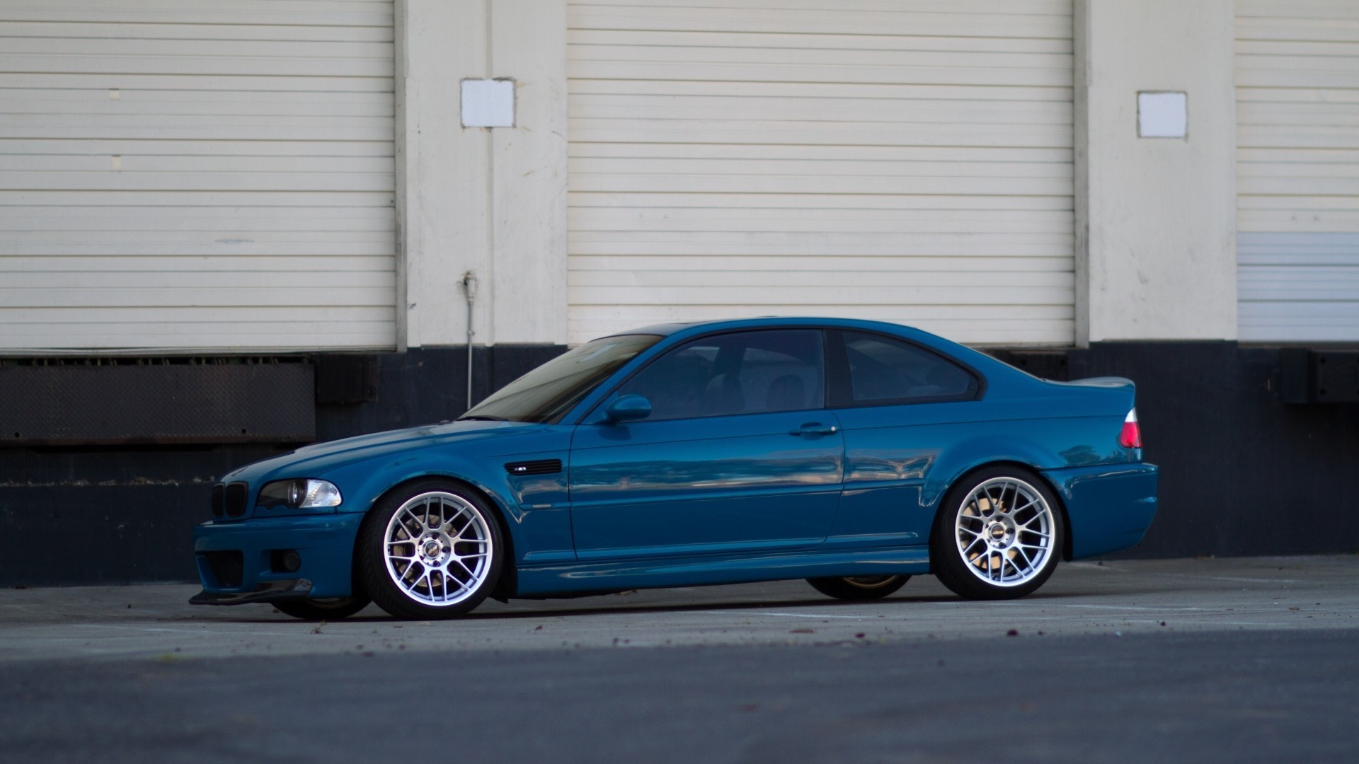 Blue BMW M3 Coupe parked in front of a warehouse HD Wallpaper