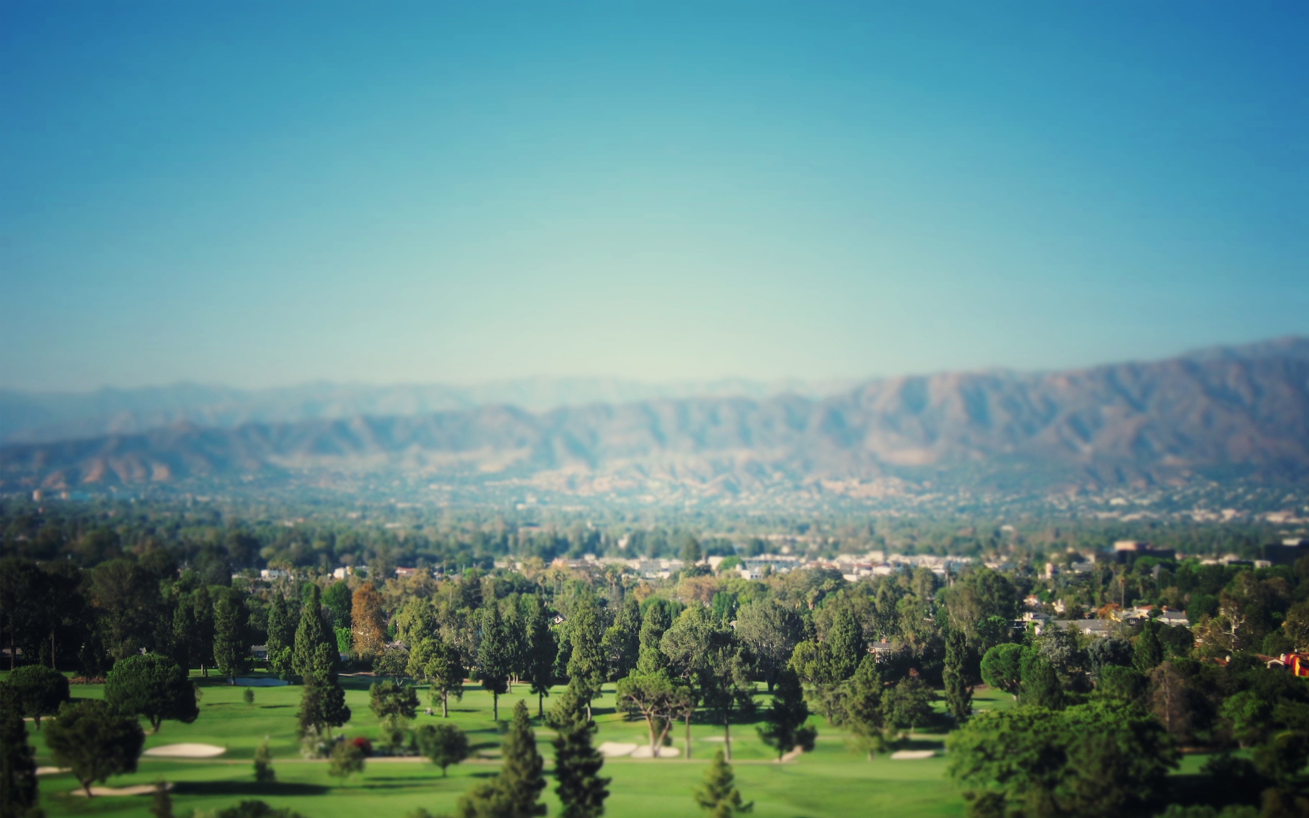 Golf course with mountains in the background HD Wallpaper