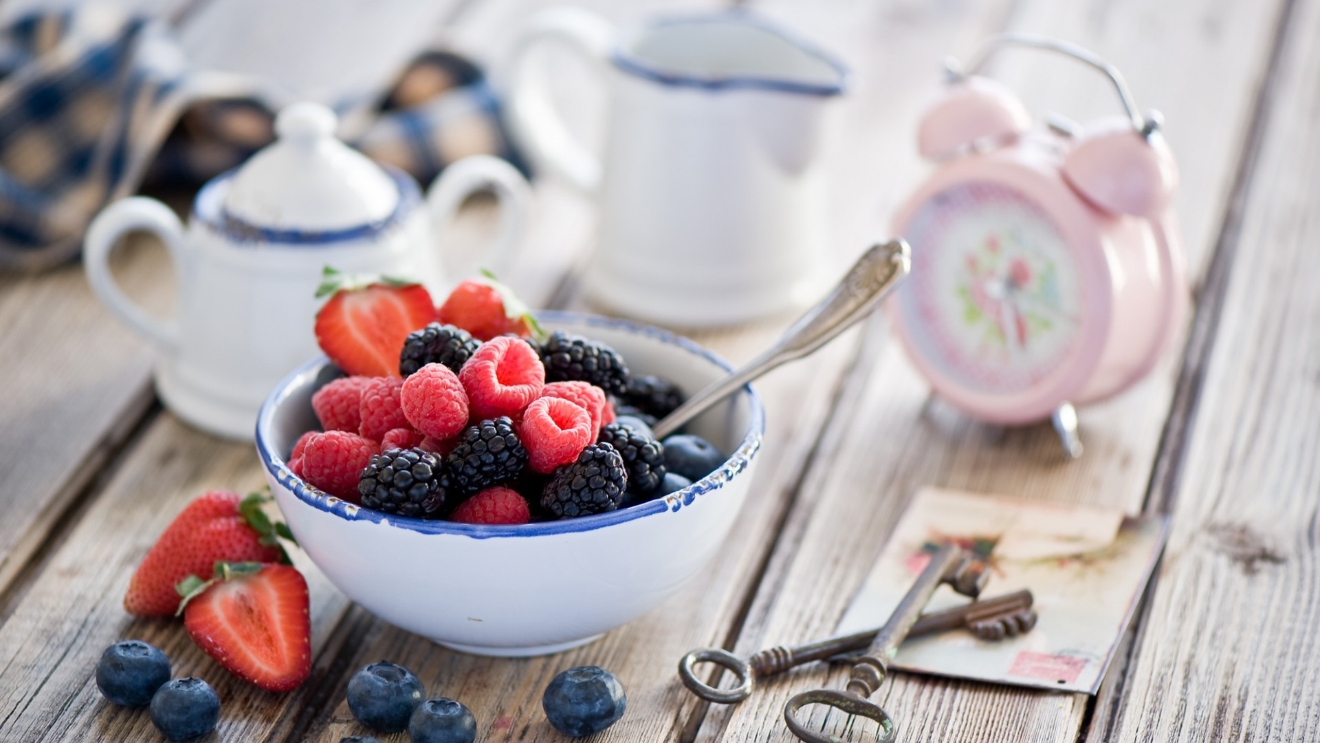 Bowl of berries with a pink alarm clock HD Wallpaper