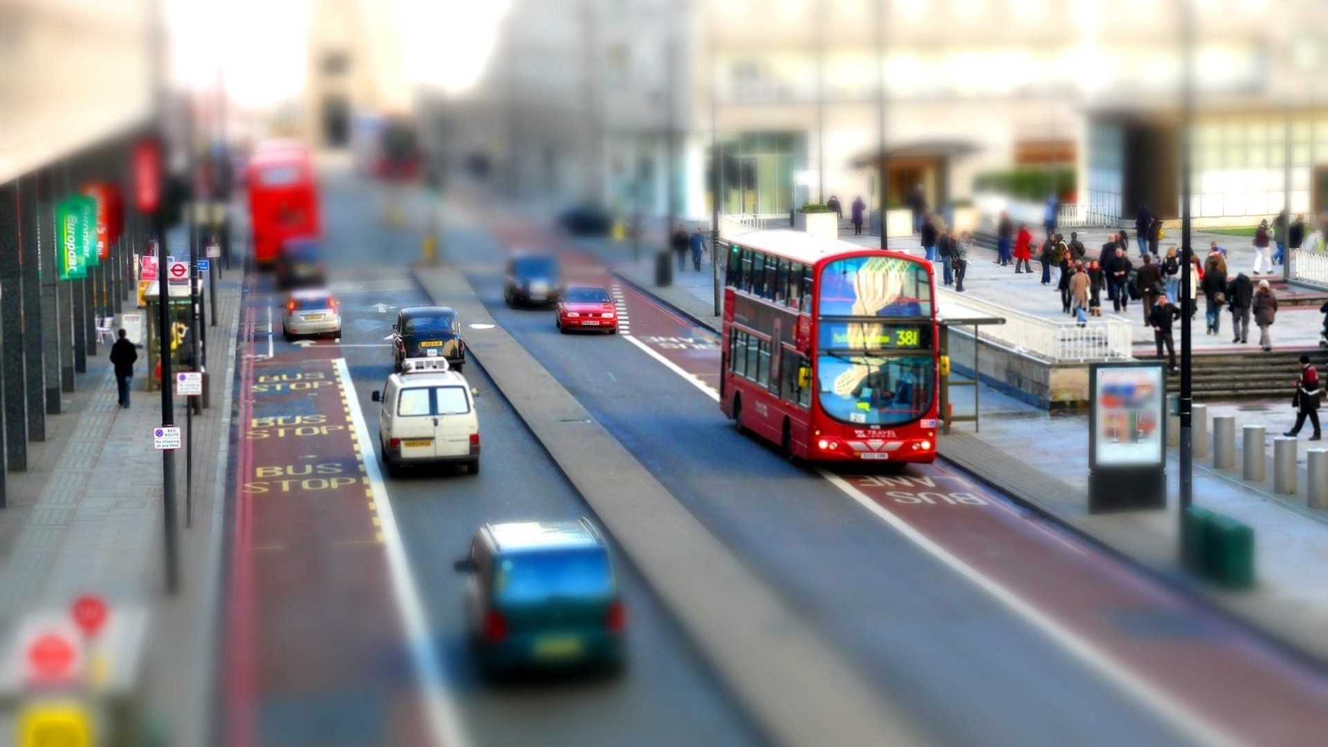 Red double-decker bus in a busy city street HD Wallpaper