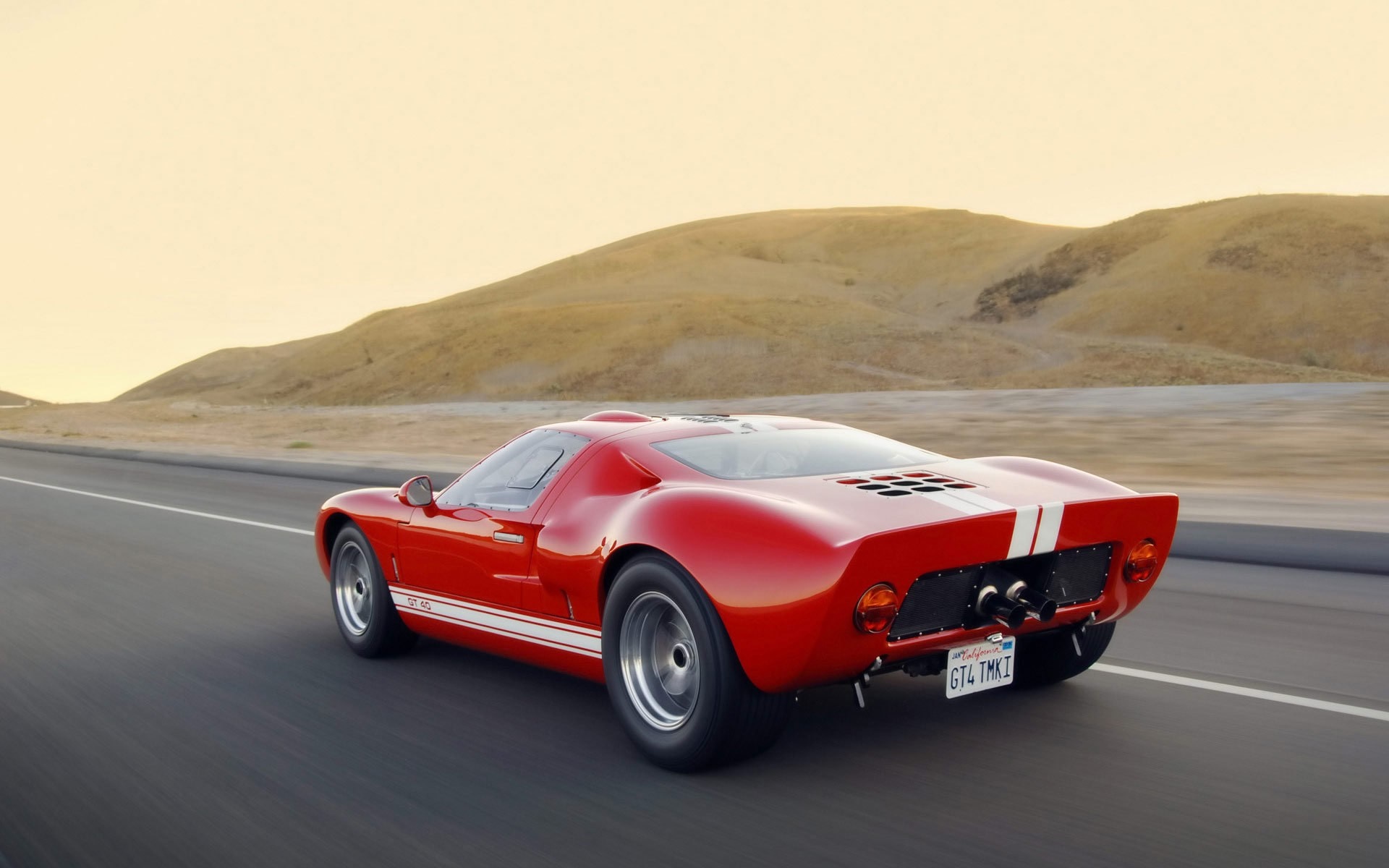 Red Ford GT40 driving on a road HD Wallpaper