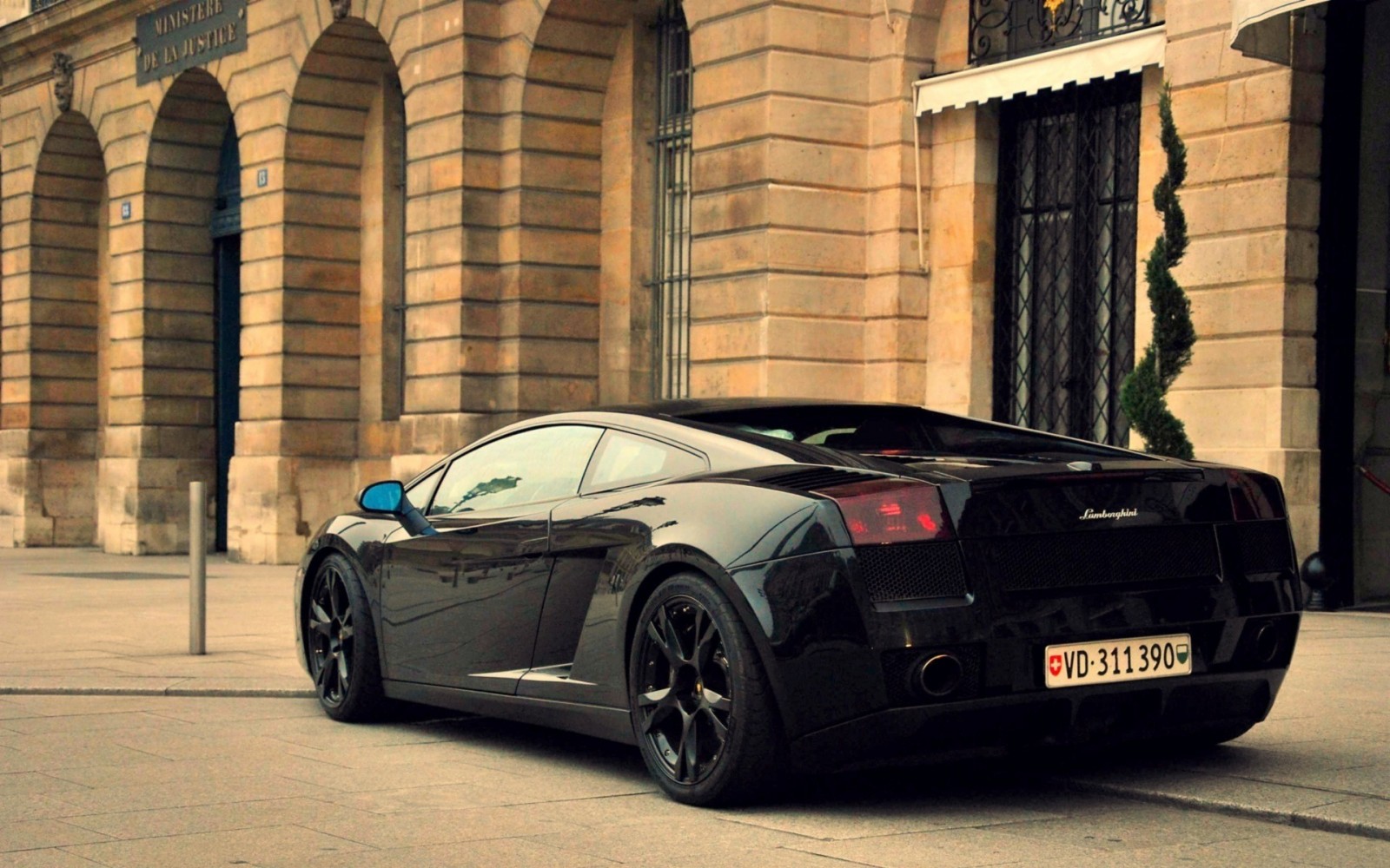 Black Lamborghini Gallardo parked in front of a building HD Wallpaper