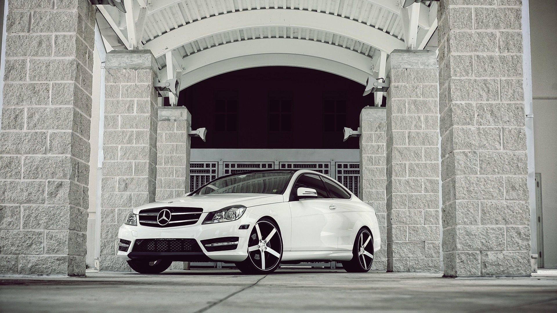 White Mercedes-Benz Coupe parked under stone archway HD Wallpaper
