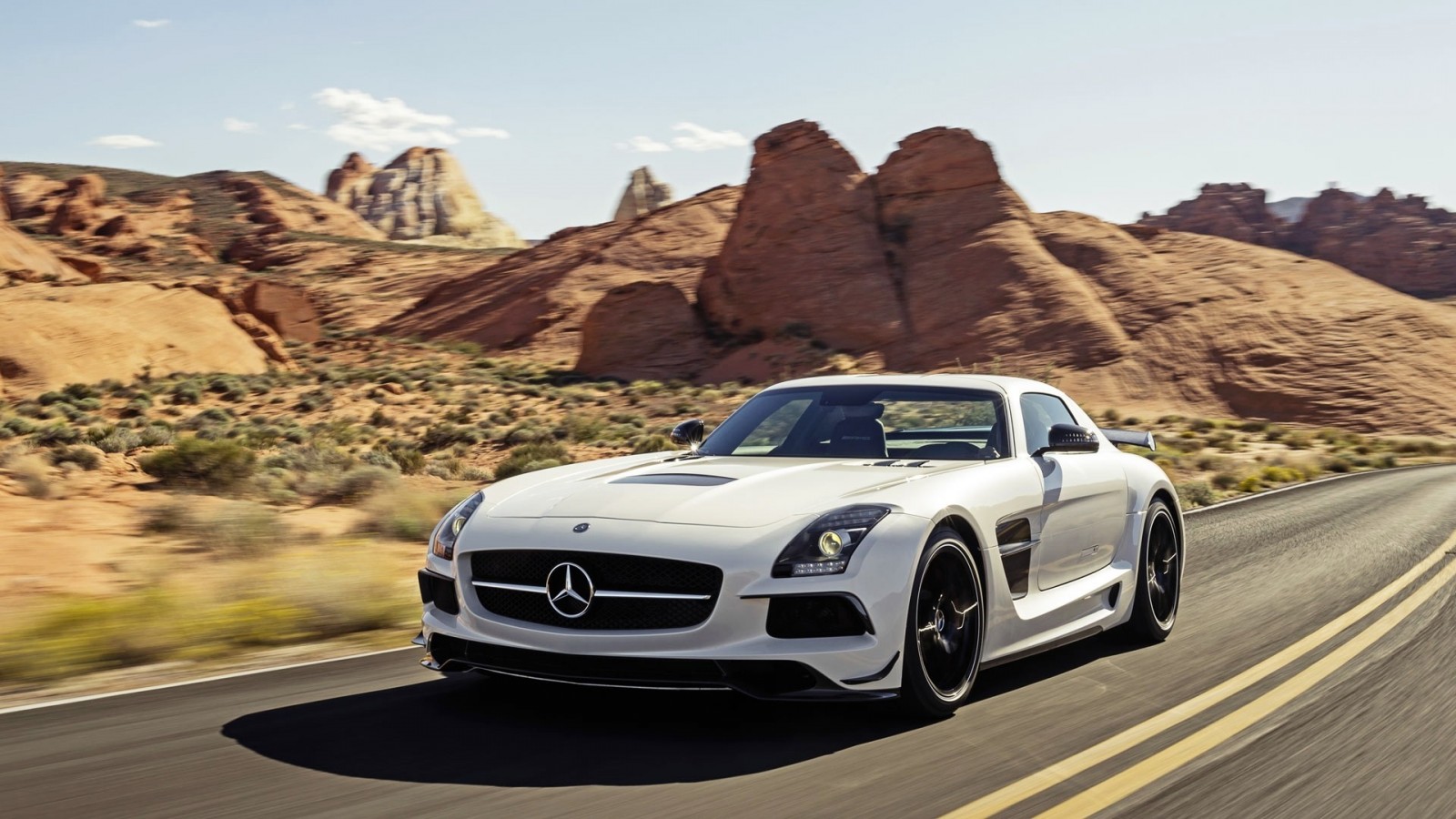White Mercedes-Benz SLS AMG driving on a desert road HD Wallpaper