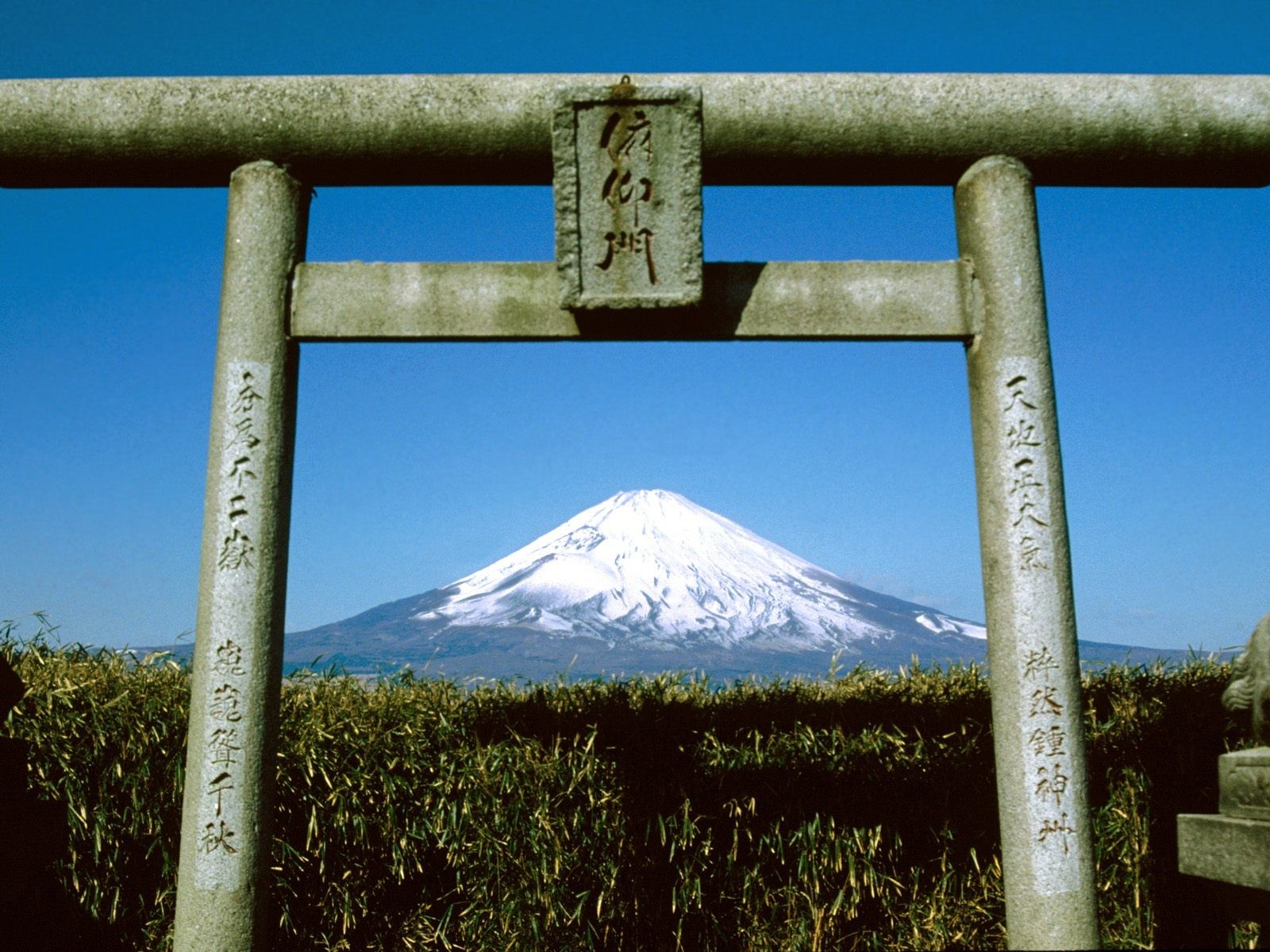 Mount Fuji seen through a stone torii gate HD Wallpaper