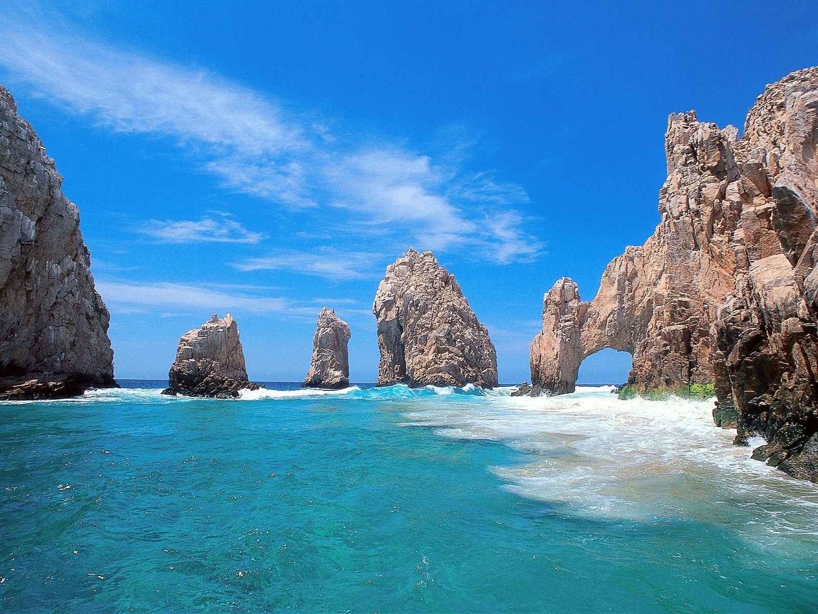 Rocky coast with natural arch and turquoise ocean HD Wallpaper