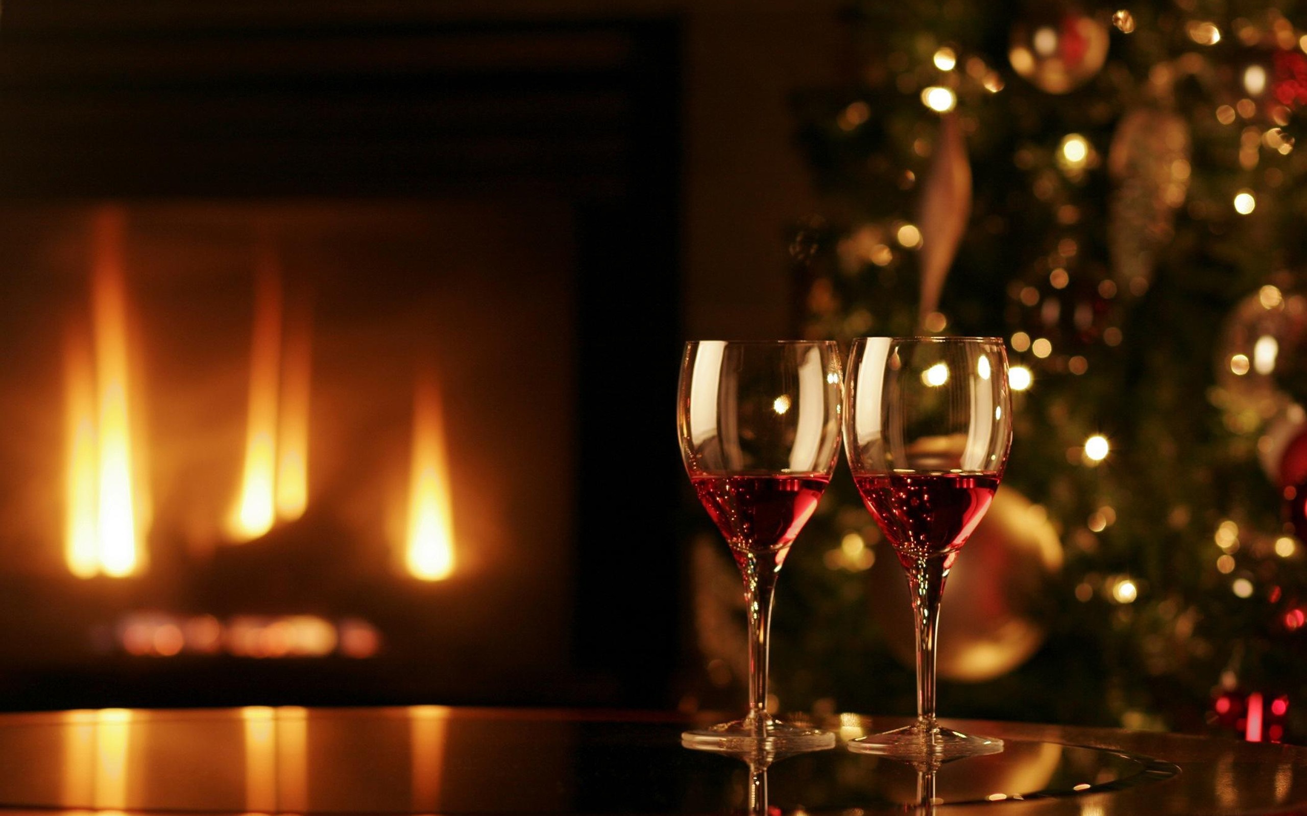 Two wine glasses by a fireplace and Christmas tree HD Wallpaper