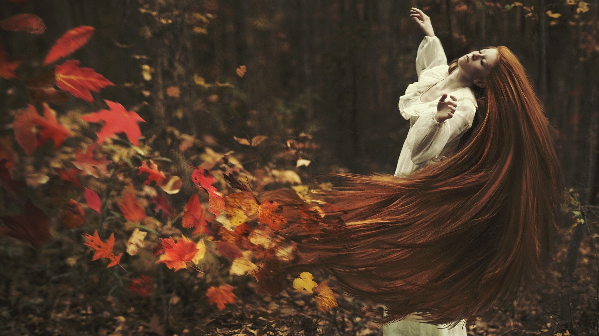Redhead woman dancing in autumn forest with falling leaves HD Wallpaper
