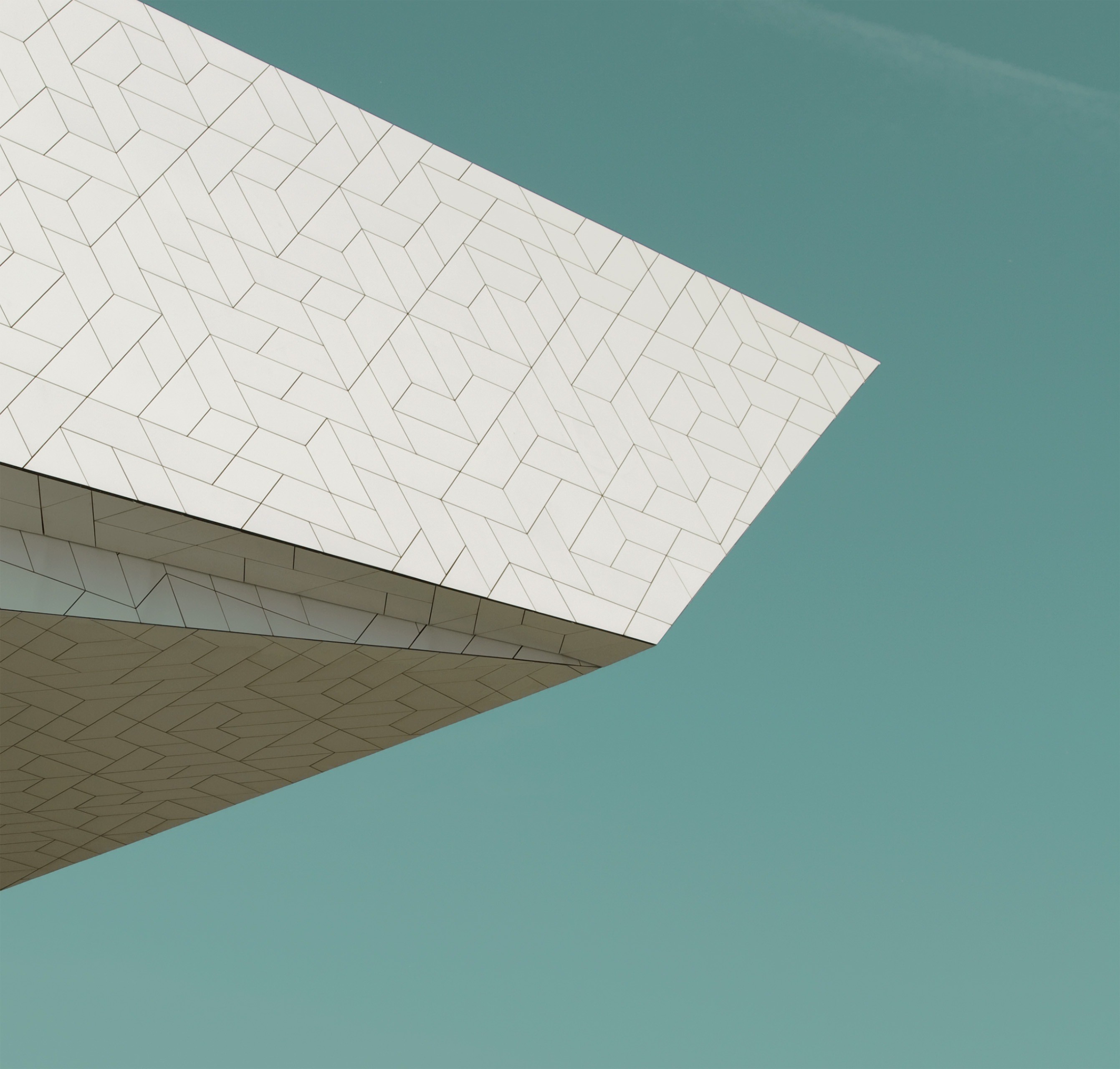 Modern building facade with geometric pattern against blue sky HD Wallpaper