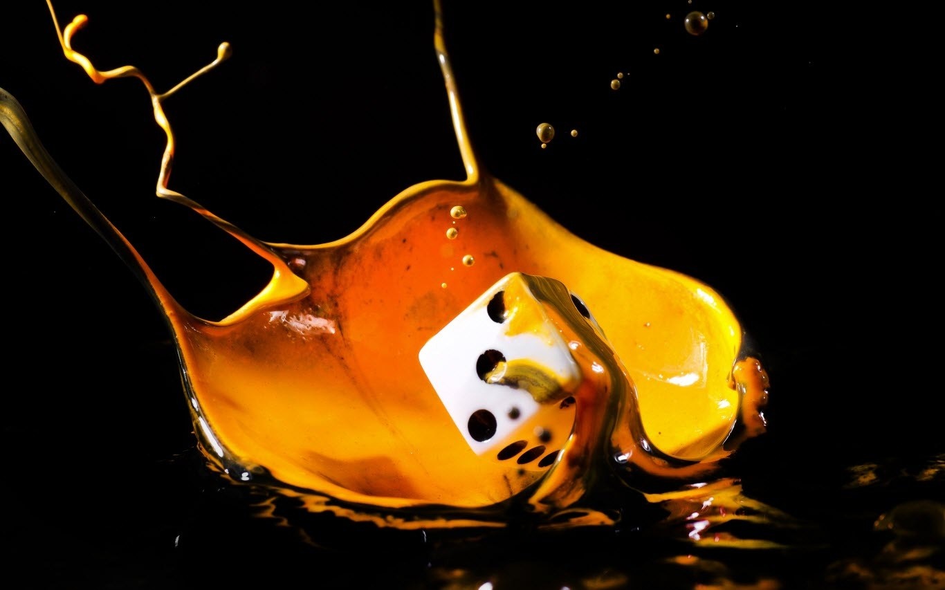 Dice splashing in yellow liquid HD Wallpaper