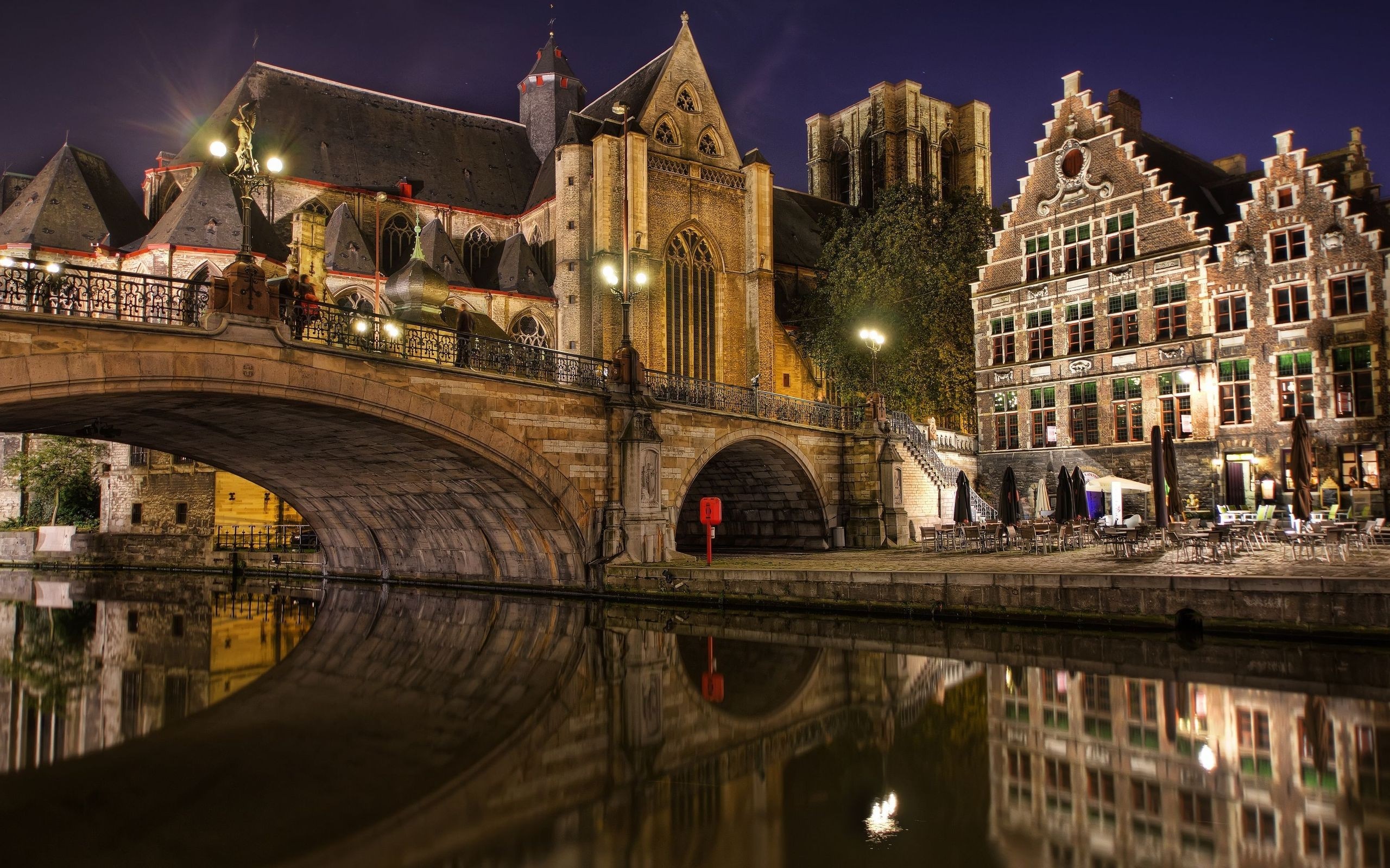 Night view of a bridge over a canal with historic buildings and reflections HD Wallpaper