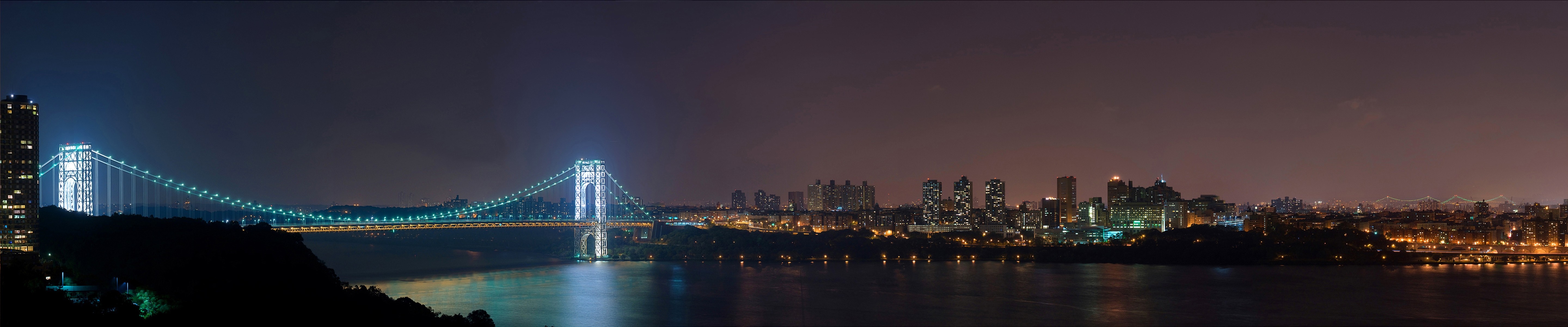 Night panorama of a suspension bridge and New York City skyline HD Wallpaper