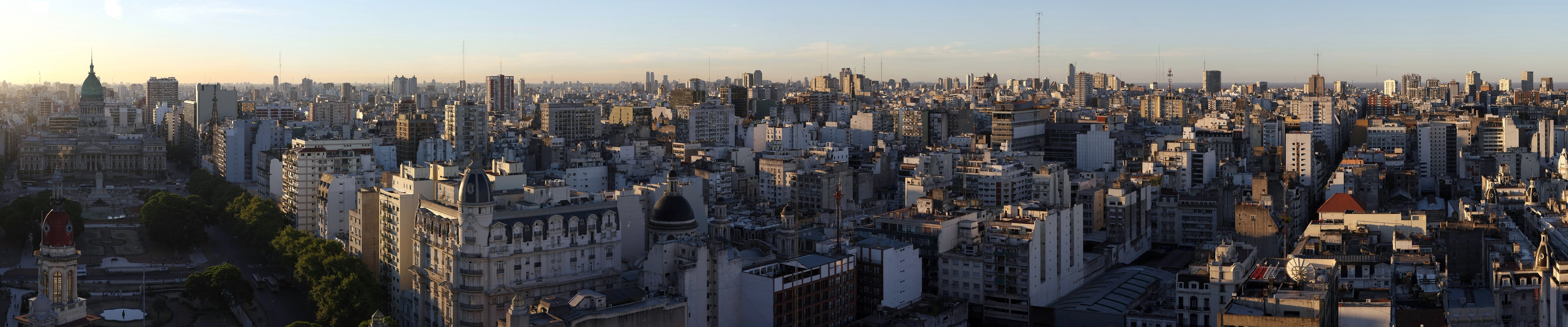Panoramic cityscape of a dense metropolis at sunset HD Wallpaper