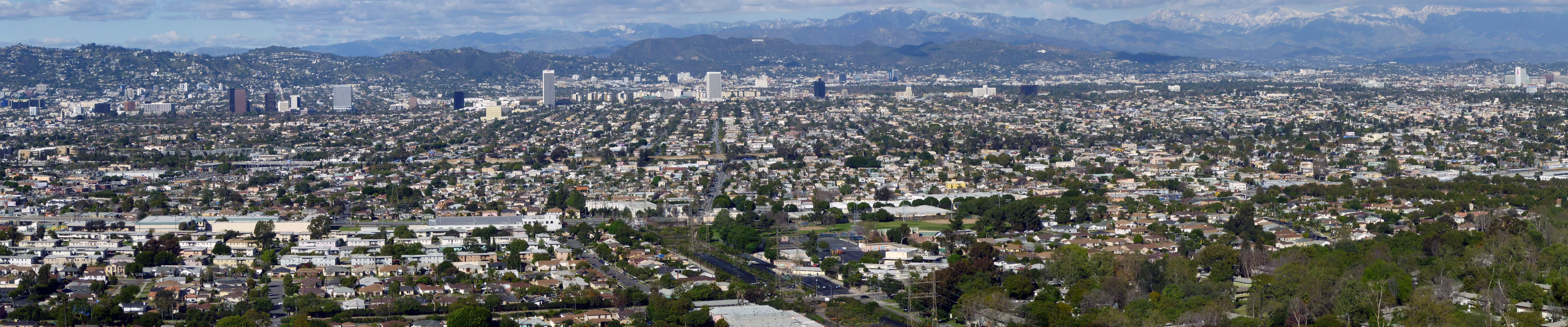 Panoramic view of Los Angeles cityscape with mountains HD Wallpaper