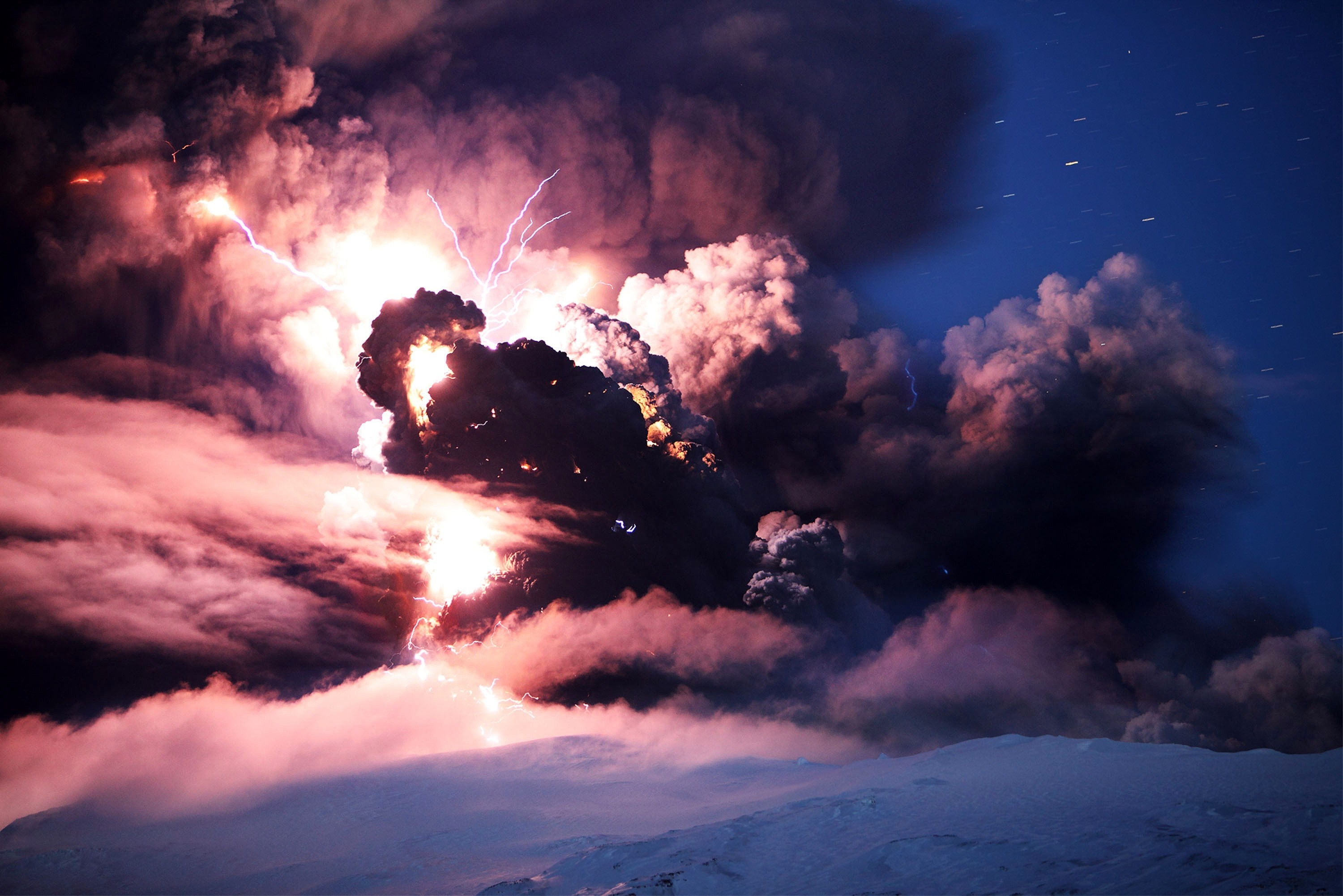 Volcanic eruption with lightning over snowy landscape HD Wallpaper