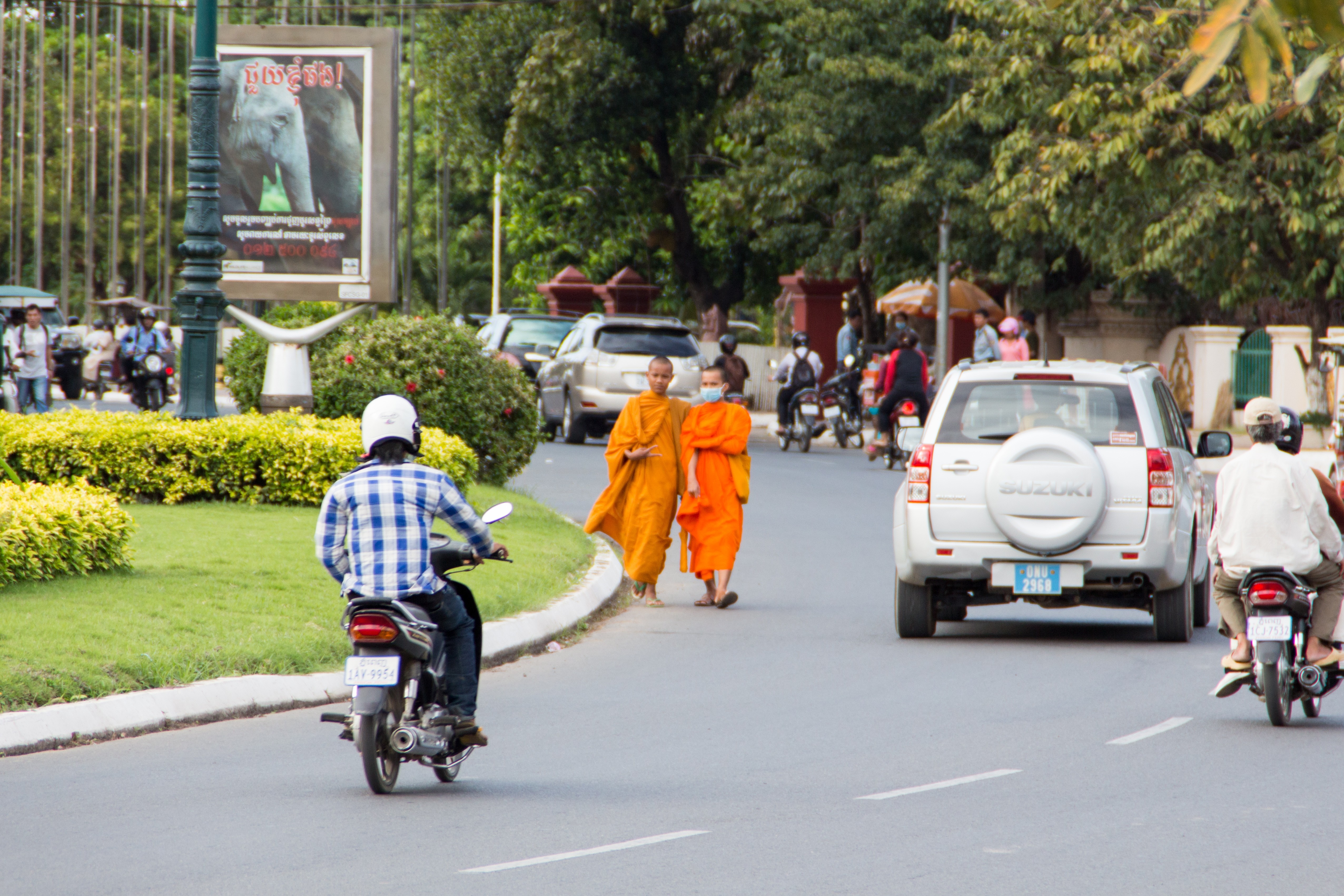 Monks walking on street with motorcycles and cars HD Wallpaper