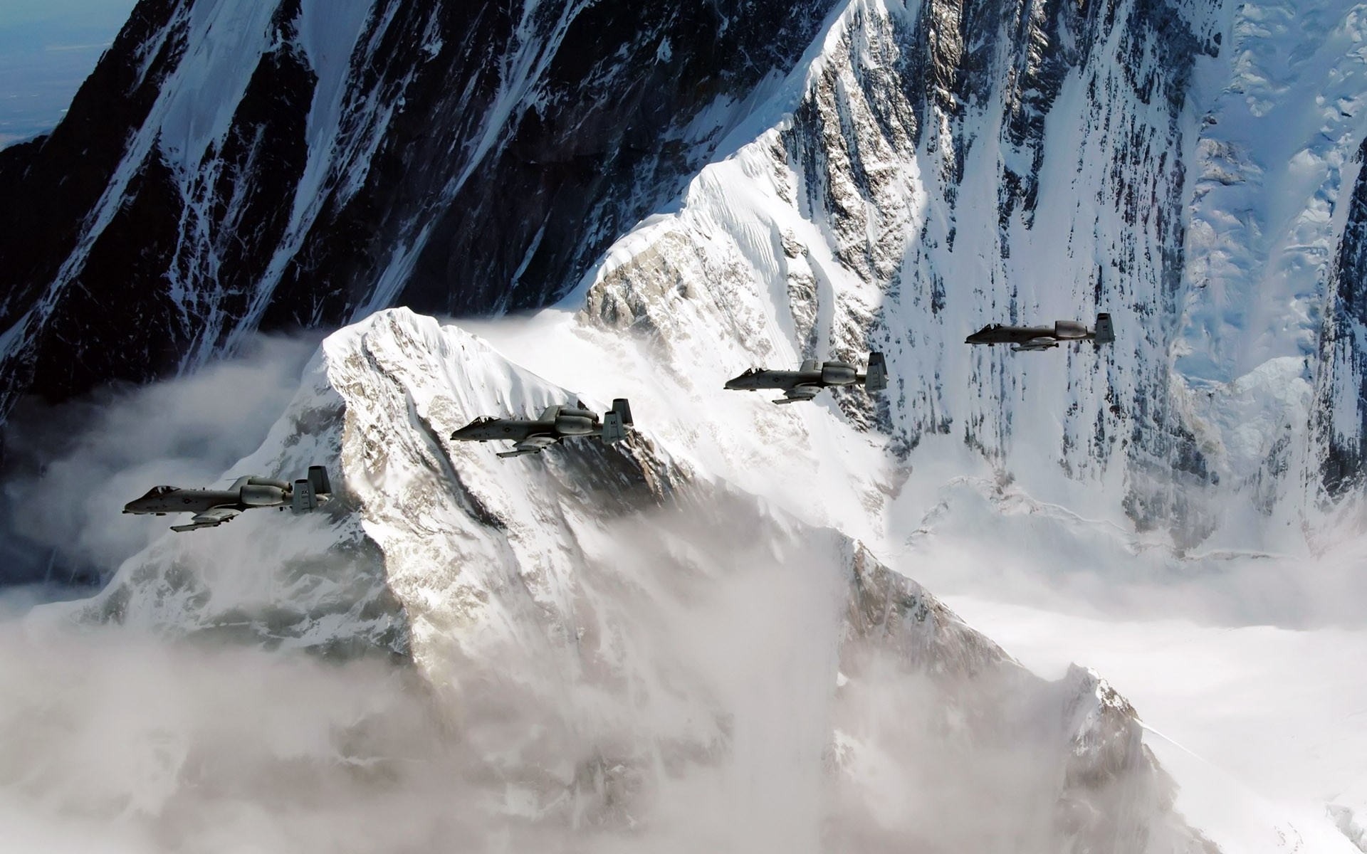 Four A-10 Thunderbolt II aircraft fly over snowy mountains HD Wallpaper