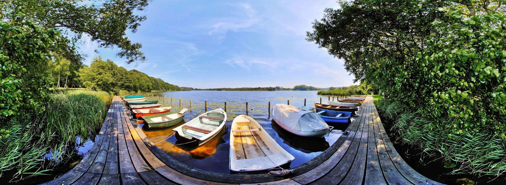 Boats docked at a wooden pier on a lake HD Wallpaper