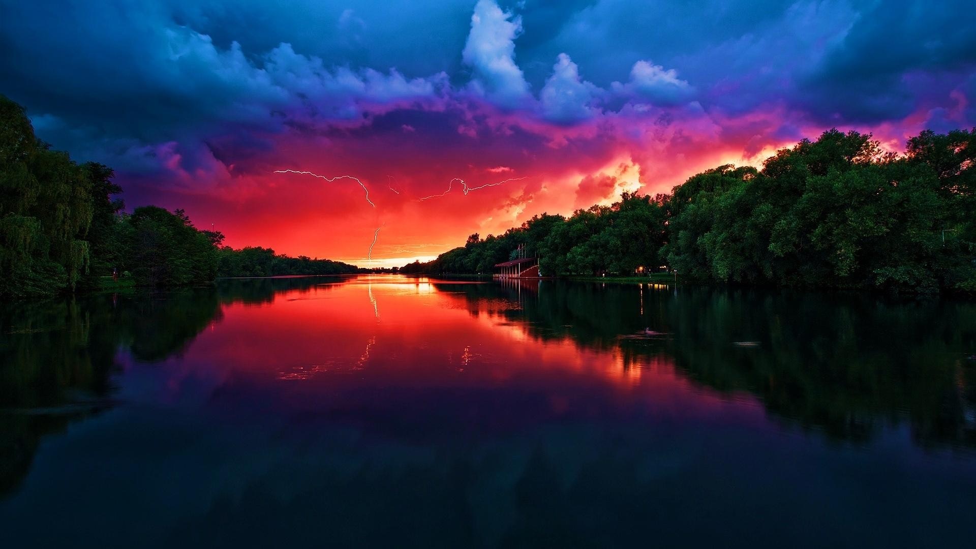Lightning strikes over a lake at sunset with colorful clouds HD Wallpaper