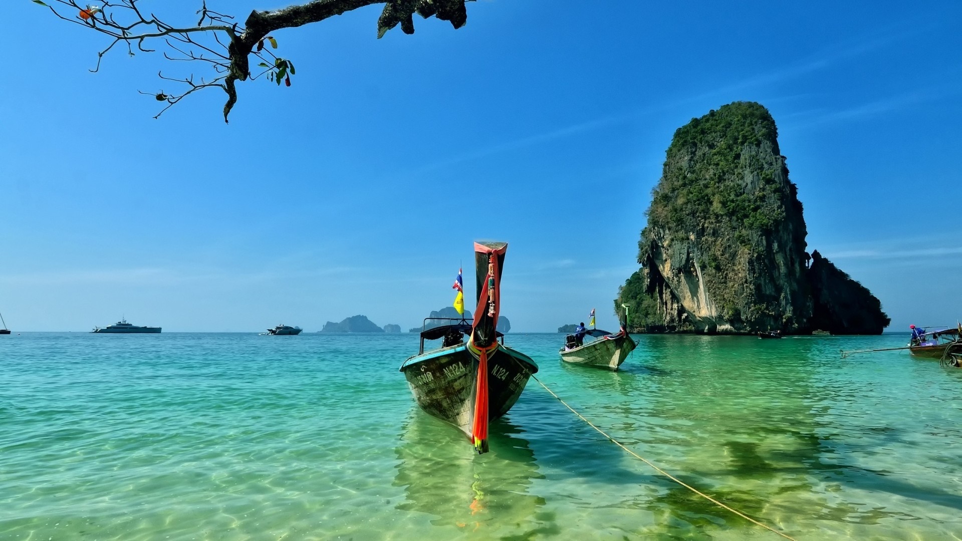 Longtail boats in a tropical bay with a large rock island HD Wallpaper