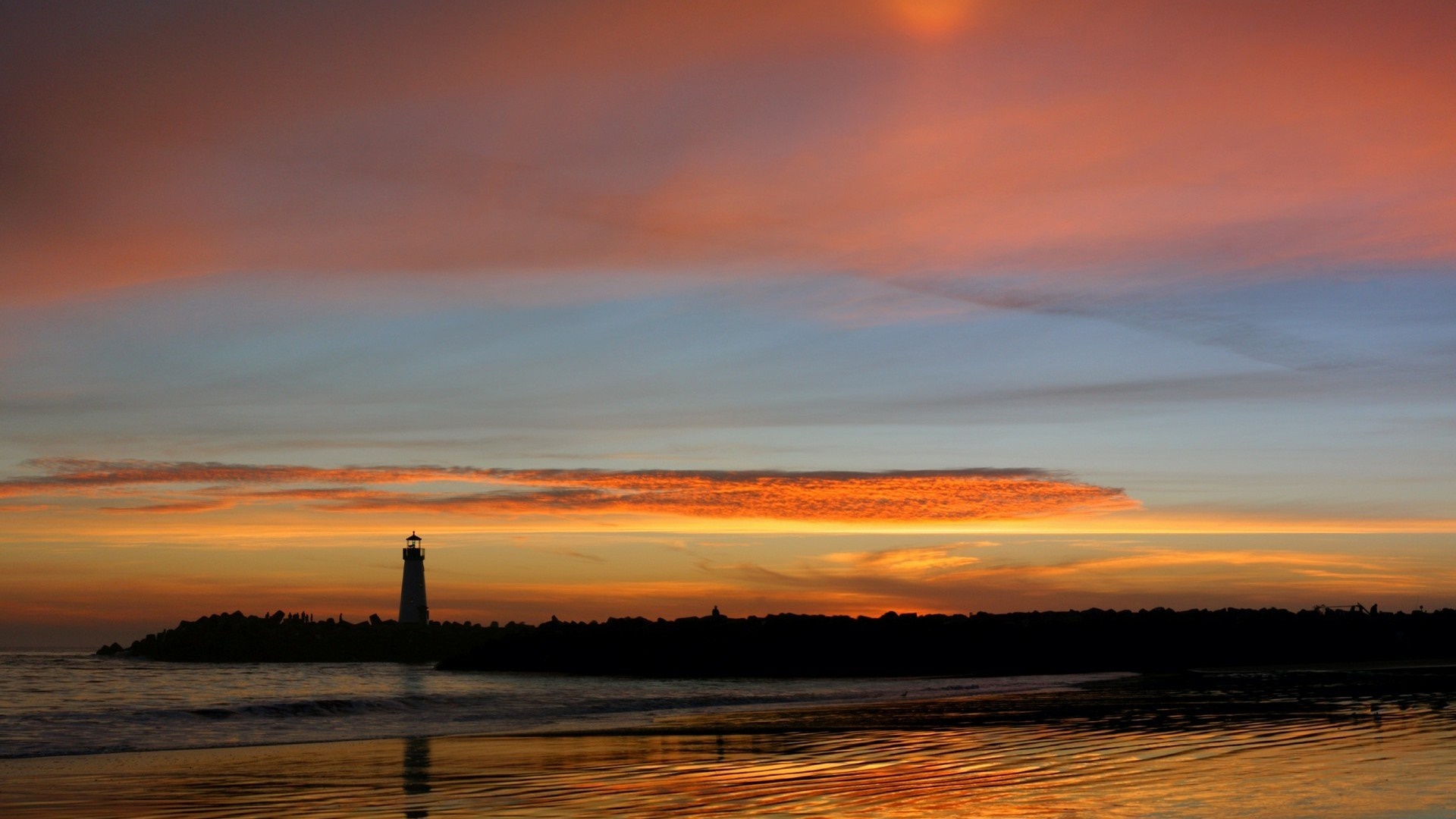 Silhouette of a lighthouse at sunset over the ocean HD Wallpaper
