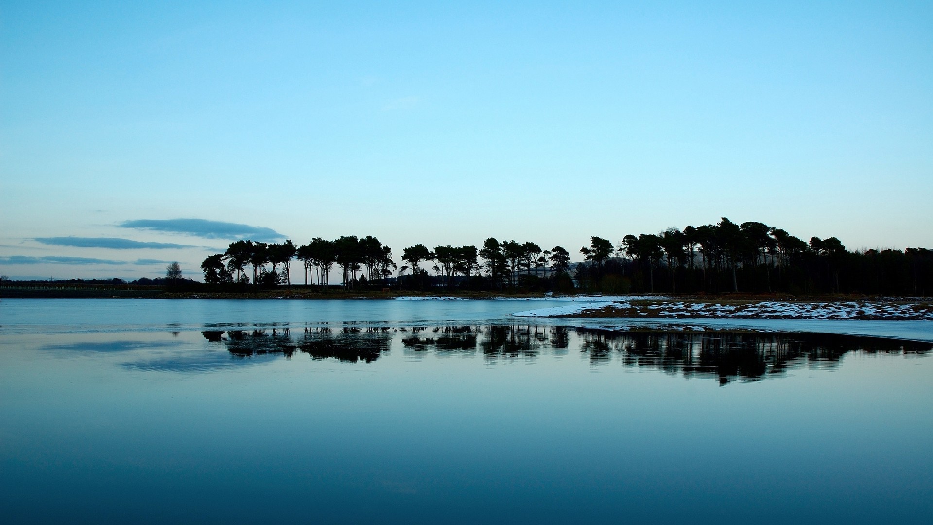 Calm lake reflecting trees at dusk HD Wallpaper