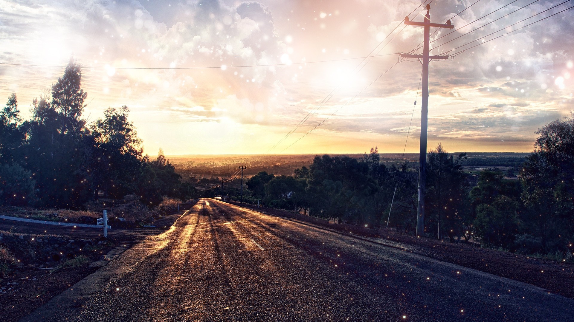 Road leading to the horizon at sunset with light particles HD Wallpaper