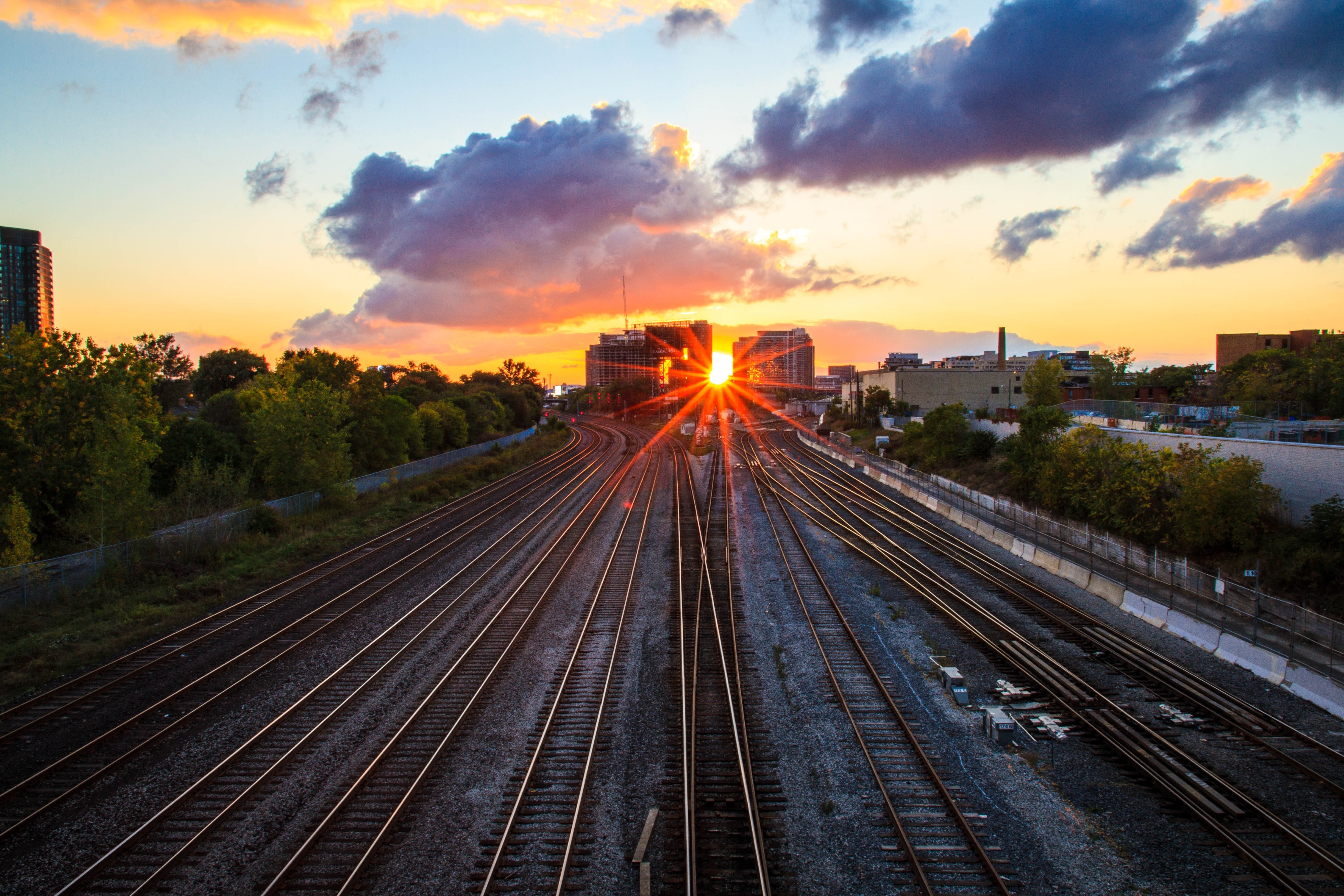 Sunset over railway tracks in a cityscape HD Wallpaper