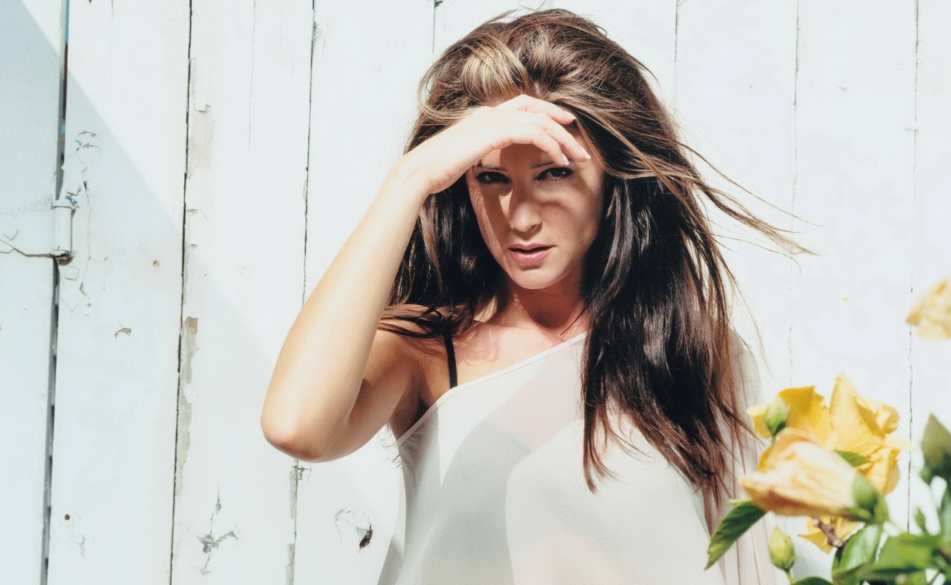 Woman with long brown hair in front of white wooden wall HD Wallpaper