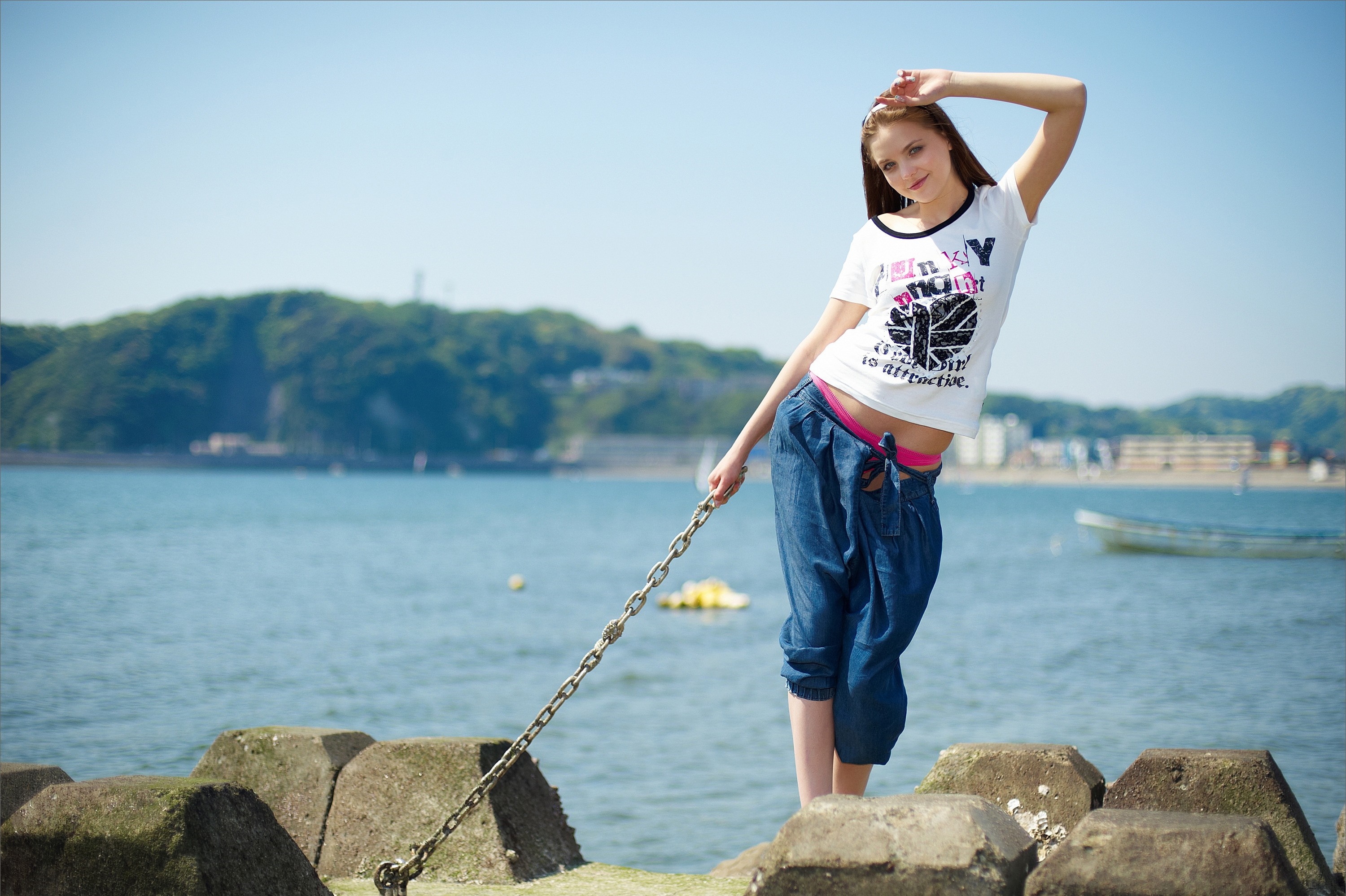 Woman on a rocky shore holding a chain HD Wallpaper
