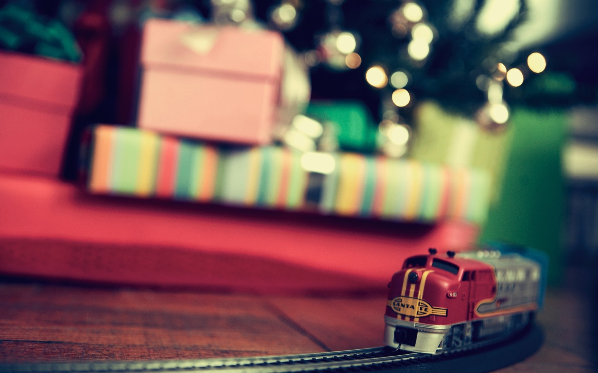 Toy train and Christmas presents under a tree HD Wallpaper