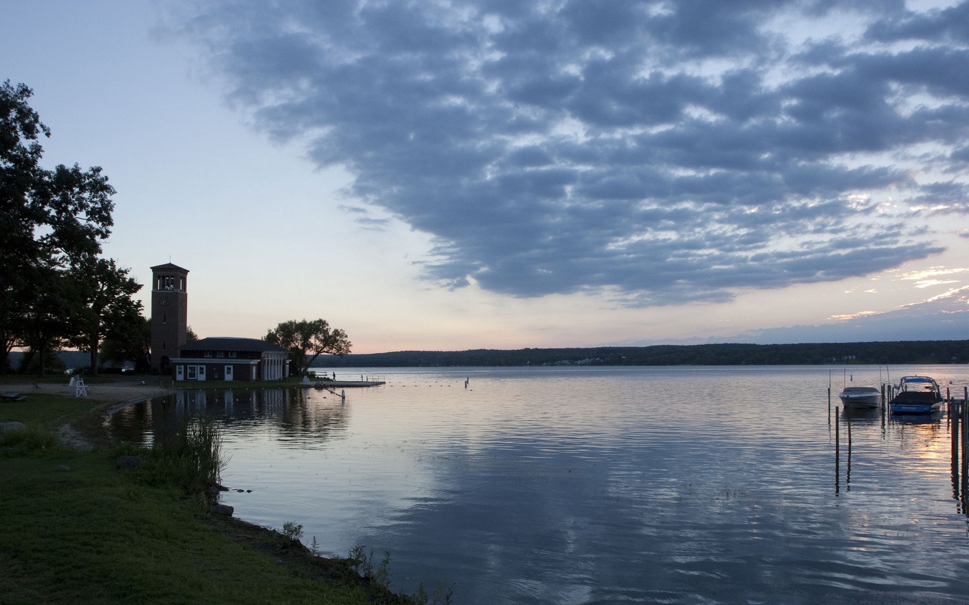 Sunset over a calm lake with a tower and boats HD Wallpaper