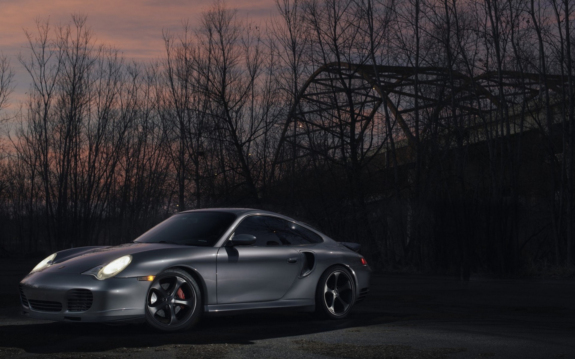 Silver Porsche 911 Turbo parked near a bridge at dusk HD Wallpaper