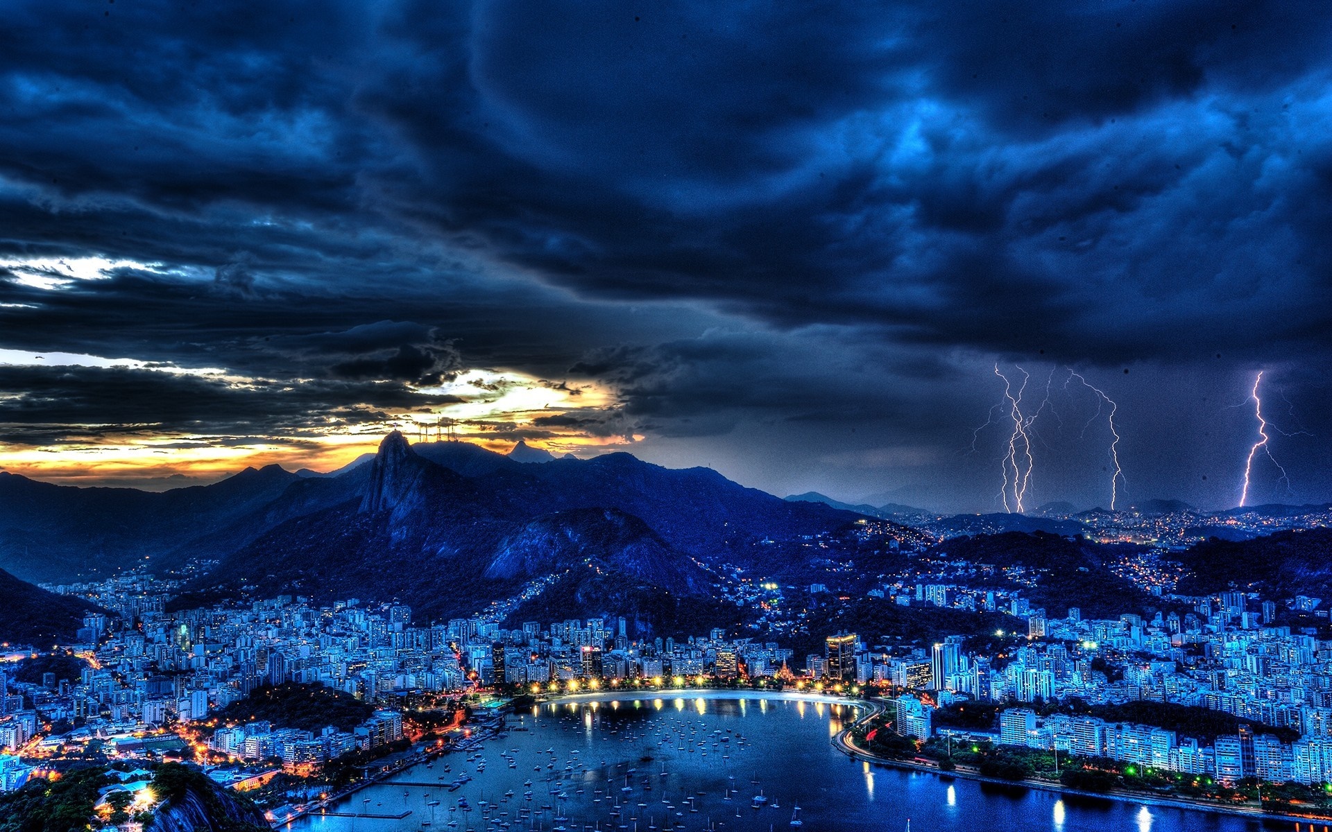 Cityscape with mountains and lightning storm at dusk HD Wallpaper