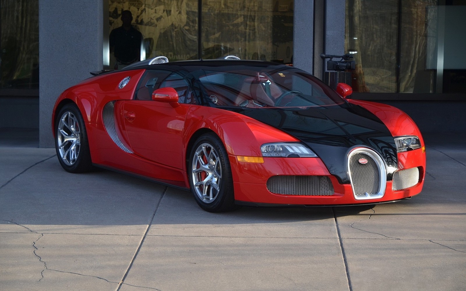 Red and black Bugatti Veyron parked on pavement HD Wallpaper