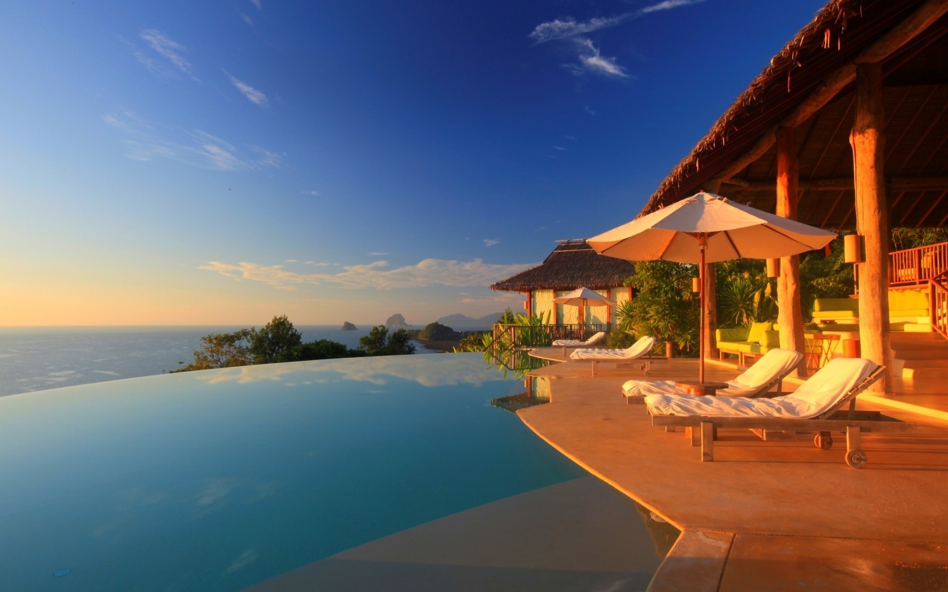 Infinity pool overlooking the ocean at sunset HD Wallpaper