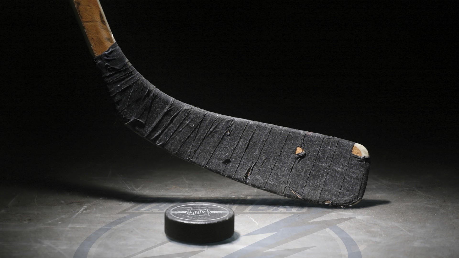 Hockey stick and puck on ice HD Wallpaper