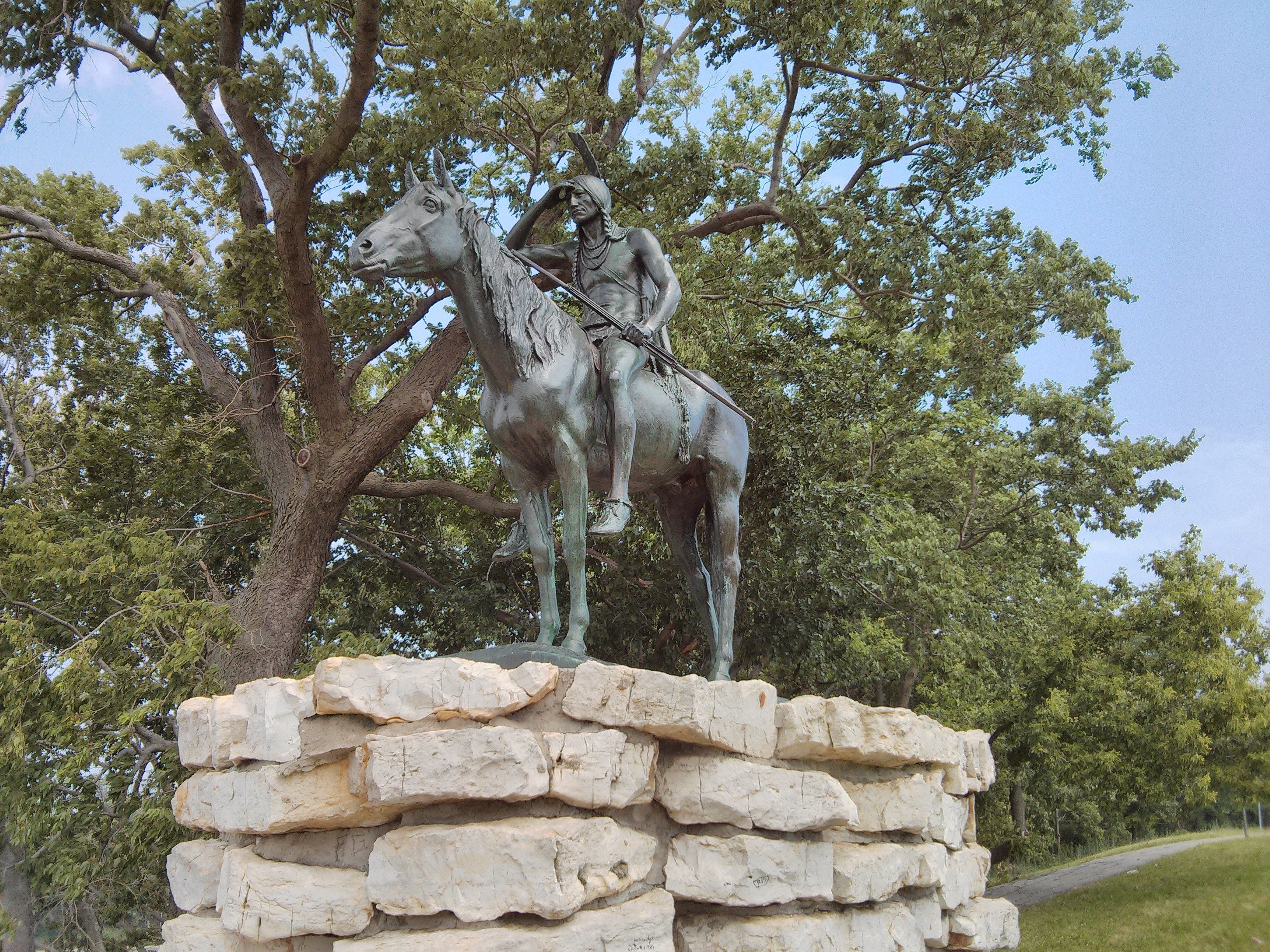 The Scout statue on a stone base in a park HD Wallpaper