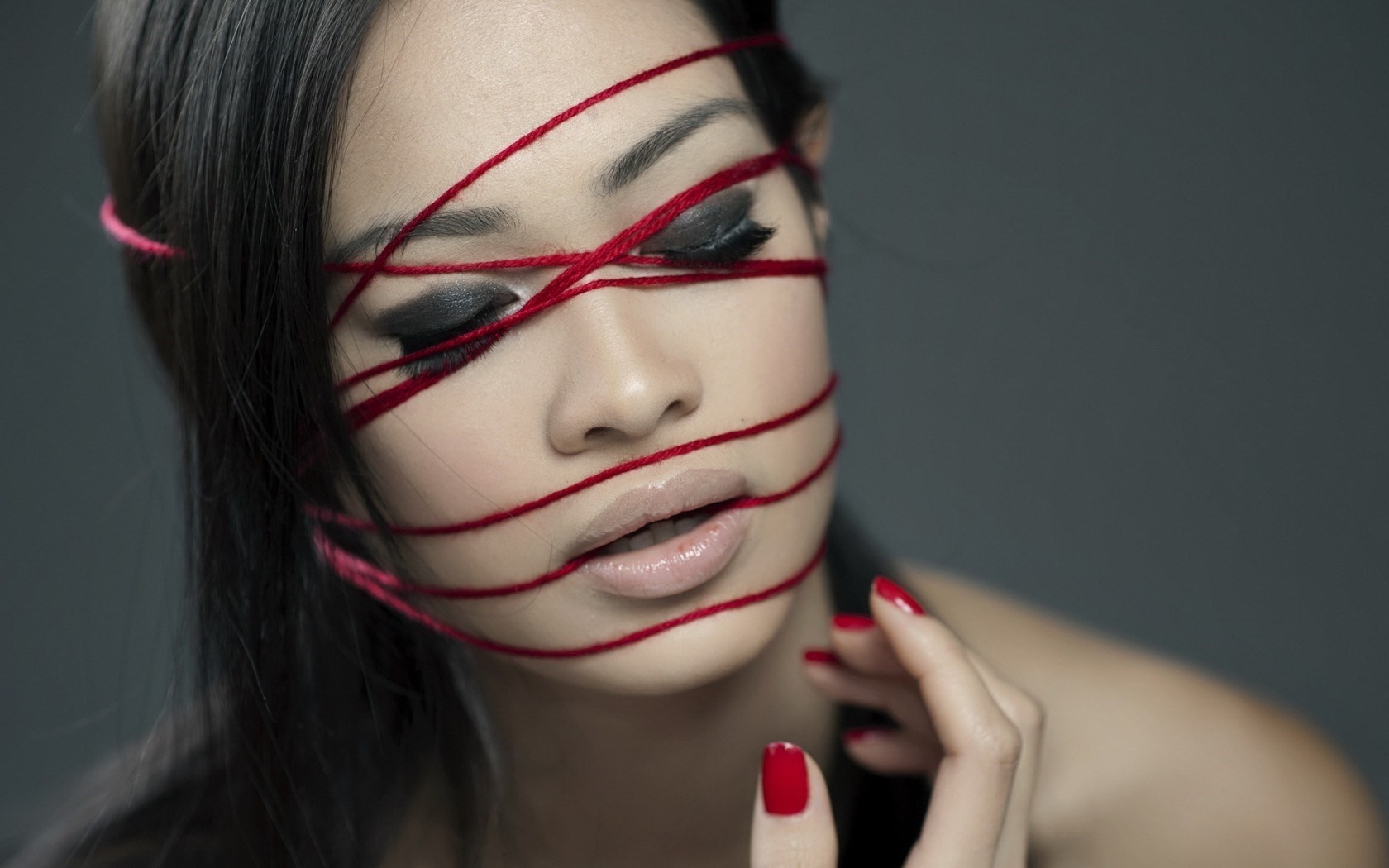 Woman with red yarn across face HD Wallpaper