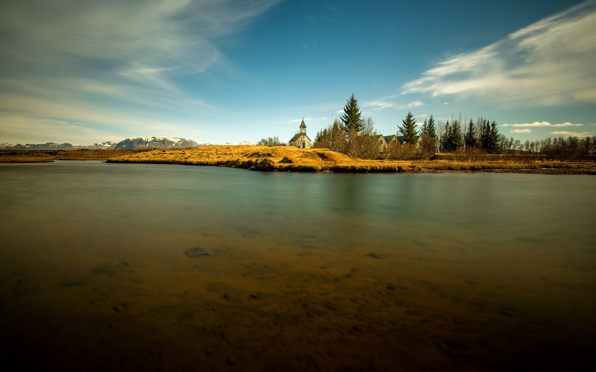 Church by a river with mountains in the background HD Wallpaper