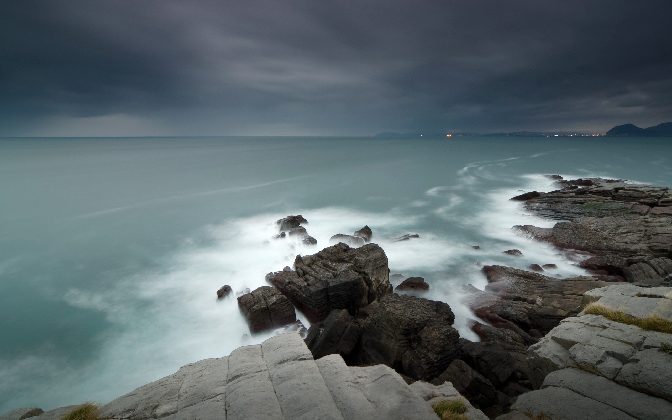 Rocky coast with waves under a cloudy sky HD Wallpaper