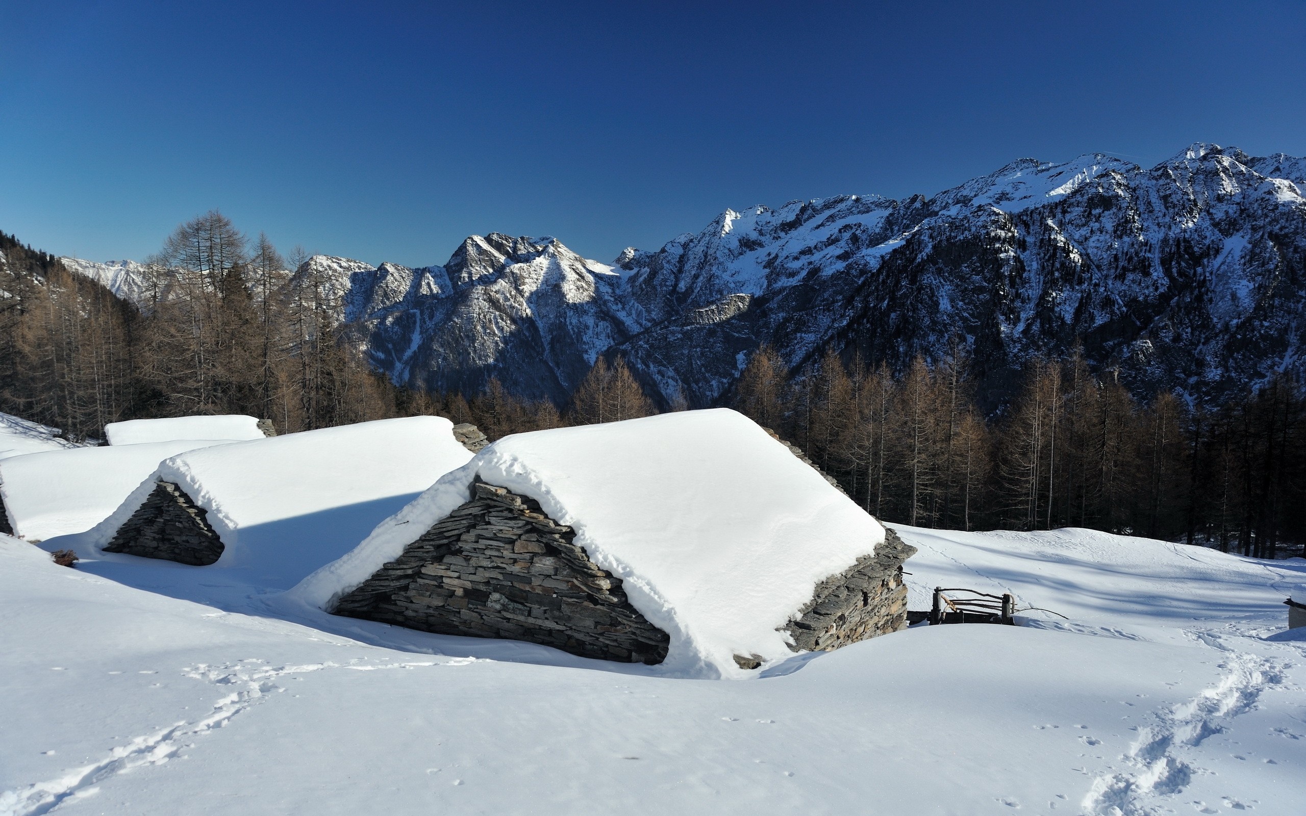 Snow-covered stone huts in the Alps HD Wallpaper