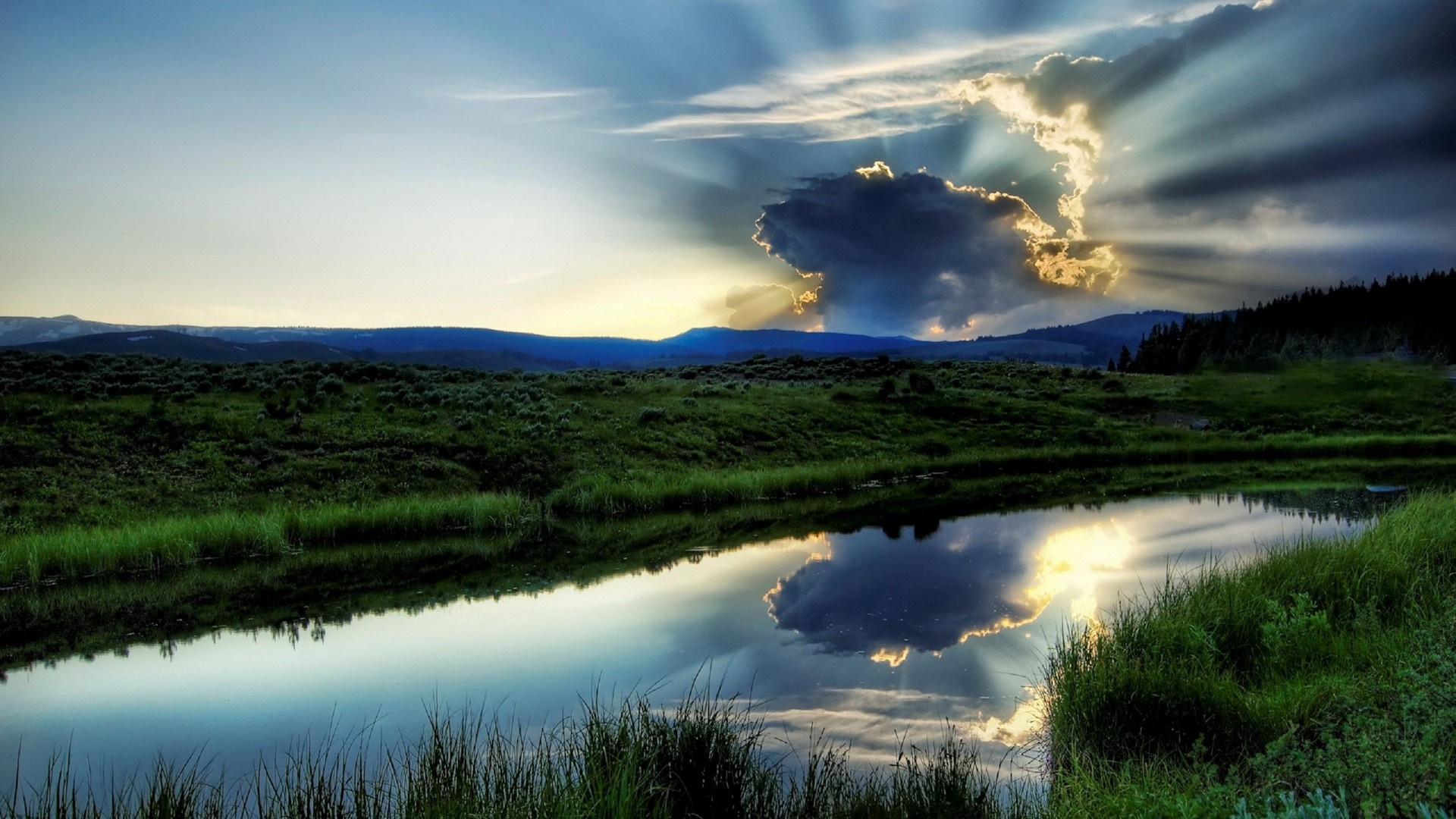 Sunlight breaking through clouds over a lake and landscape HD Wallpaper