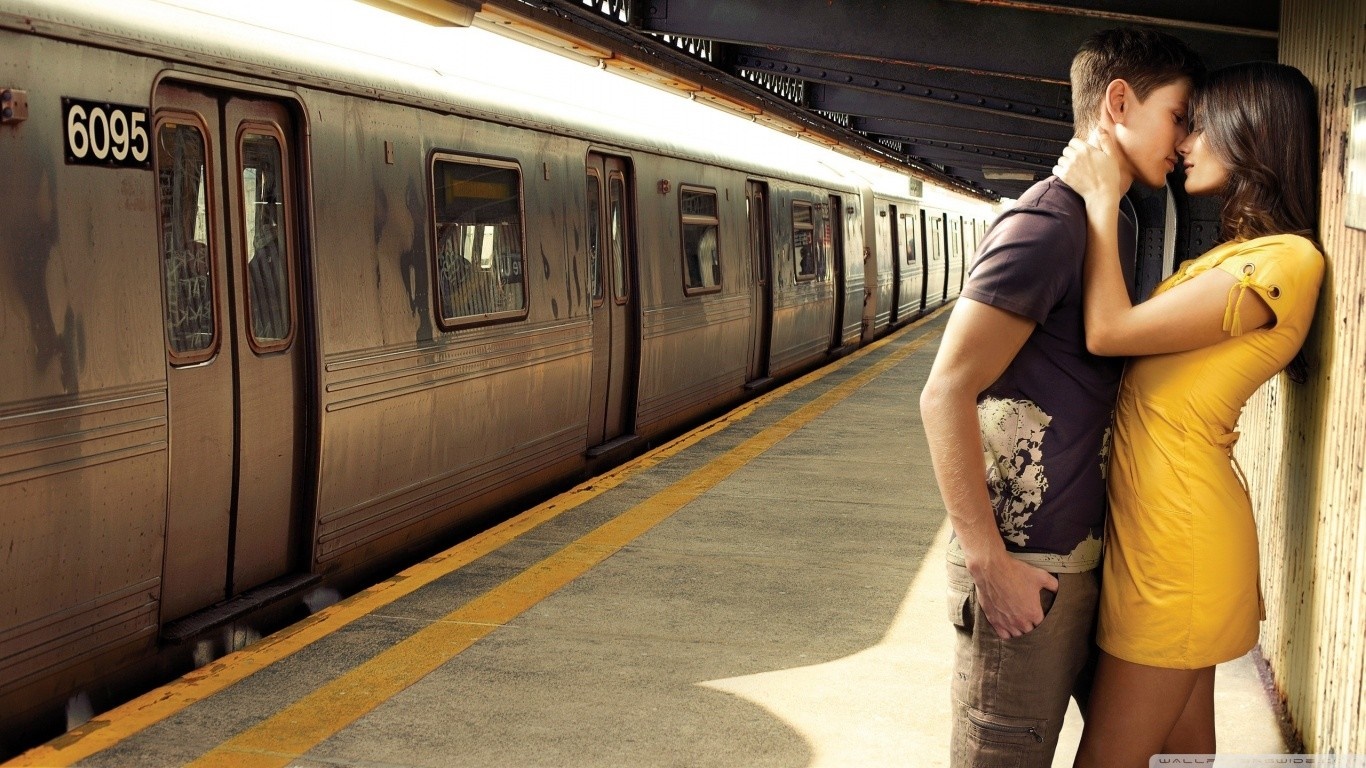 Couple kissing on a subway platform HD Wallpaper