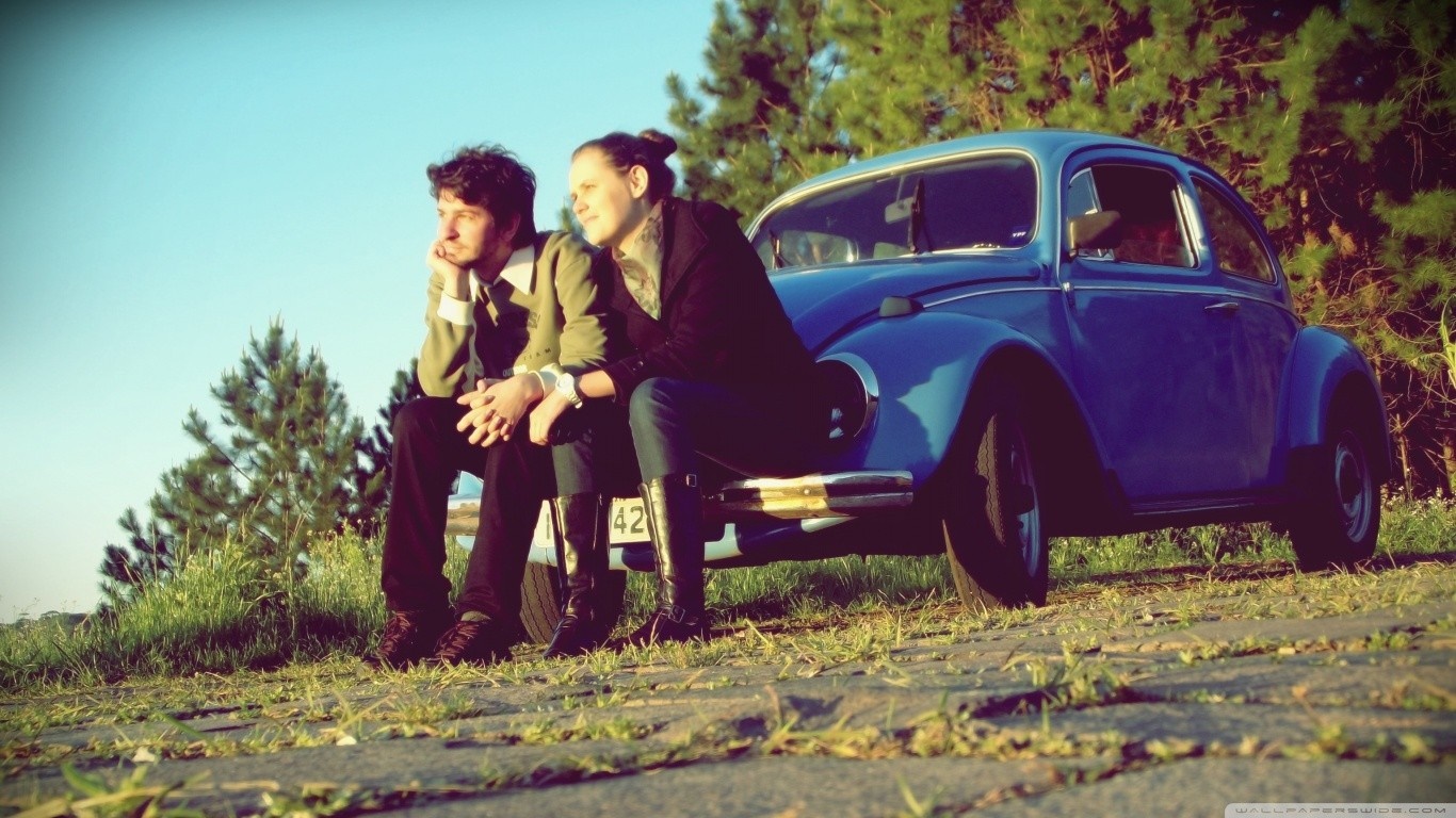 Couple sitting on a blue Volkswagen Beetle HD Wallpaper