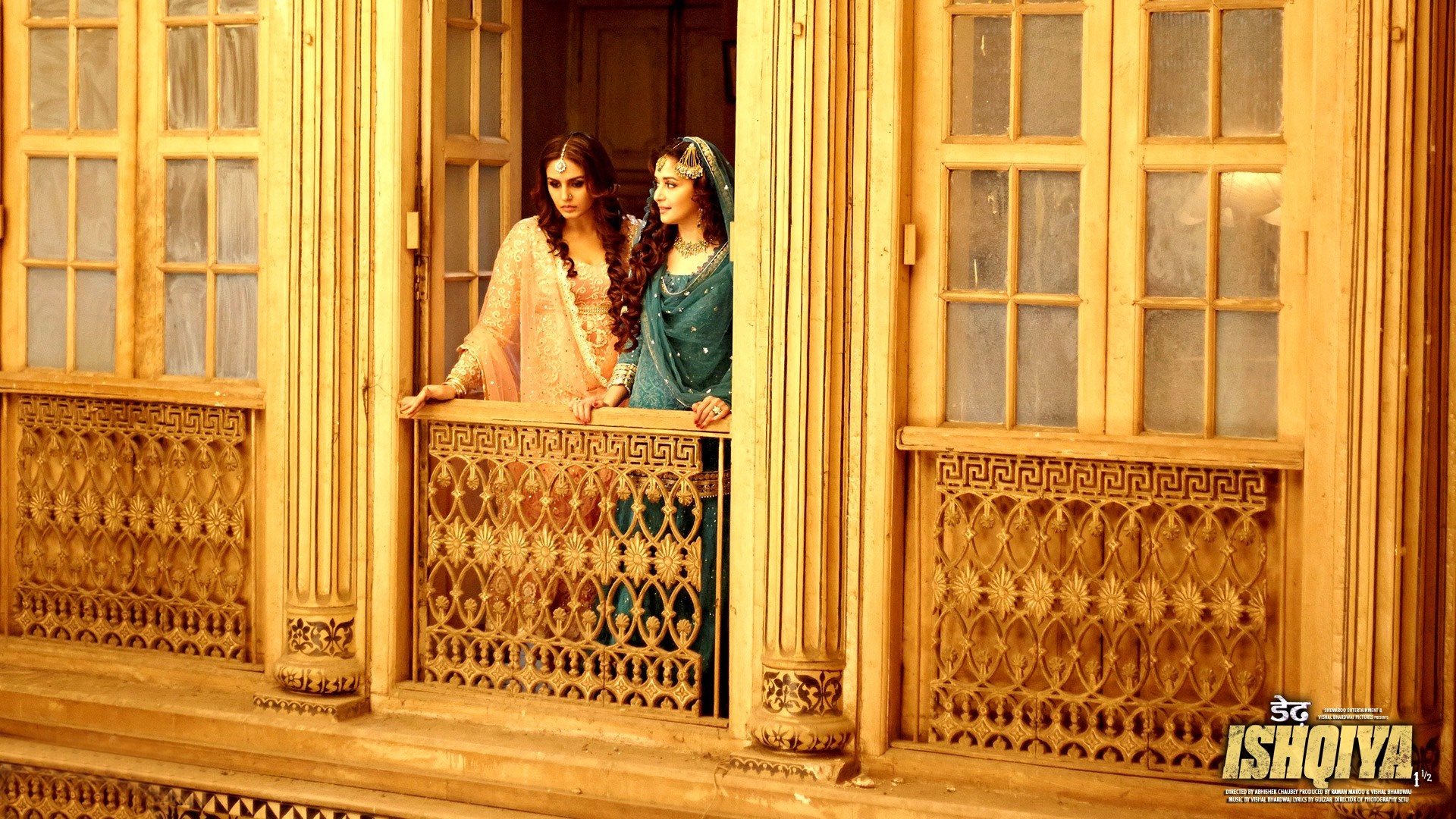 Two women in traditional Indian attire looking out of a wooden balcony HD Wallpaper