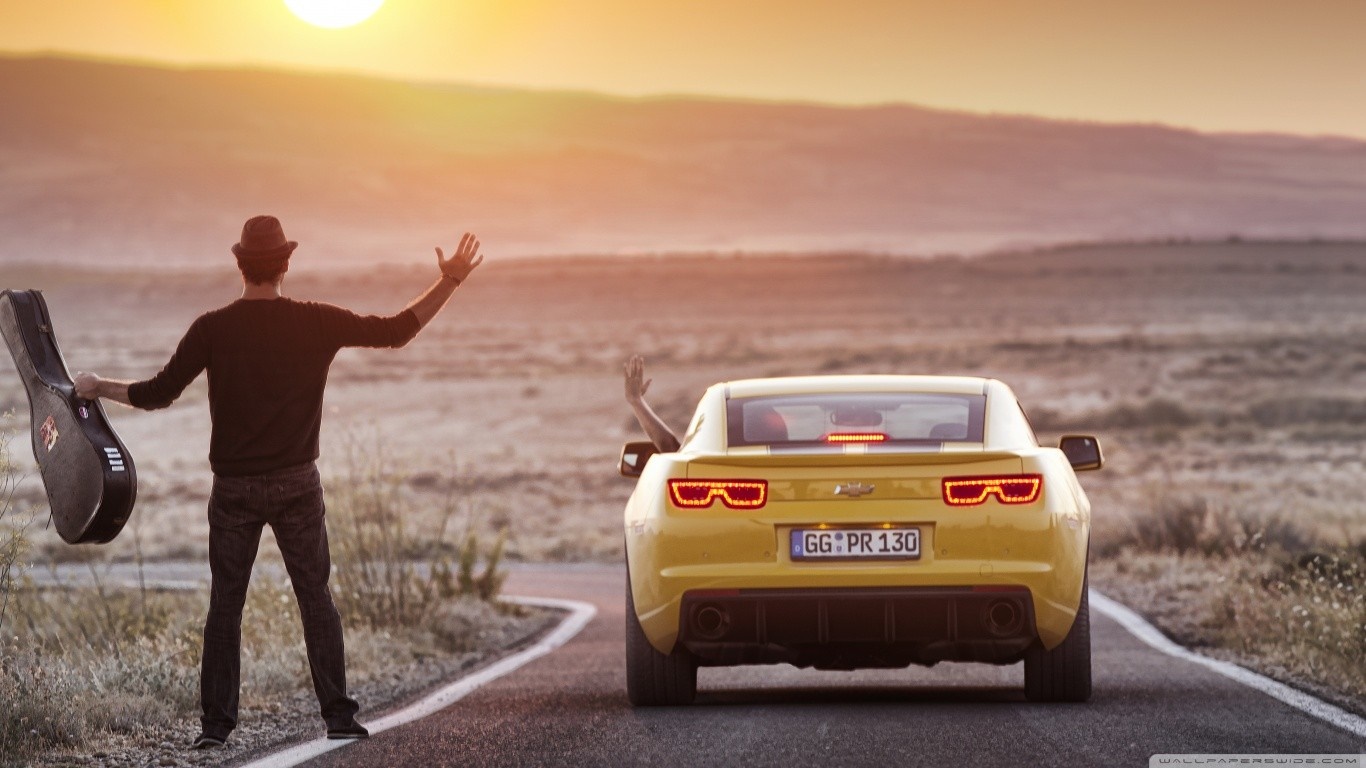Man with guitar and yellow car at sunset HD Wallpaper