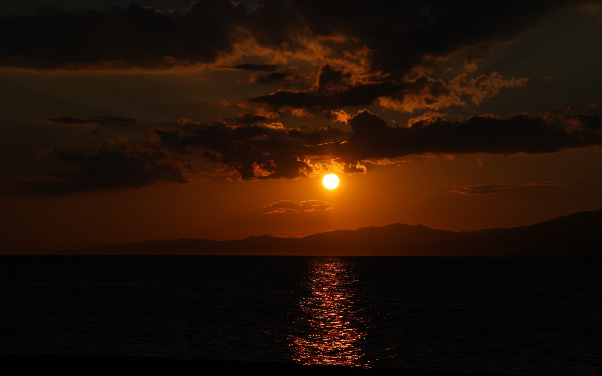 Sunset over the sea with clouds and mountains HD Wallpaper