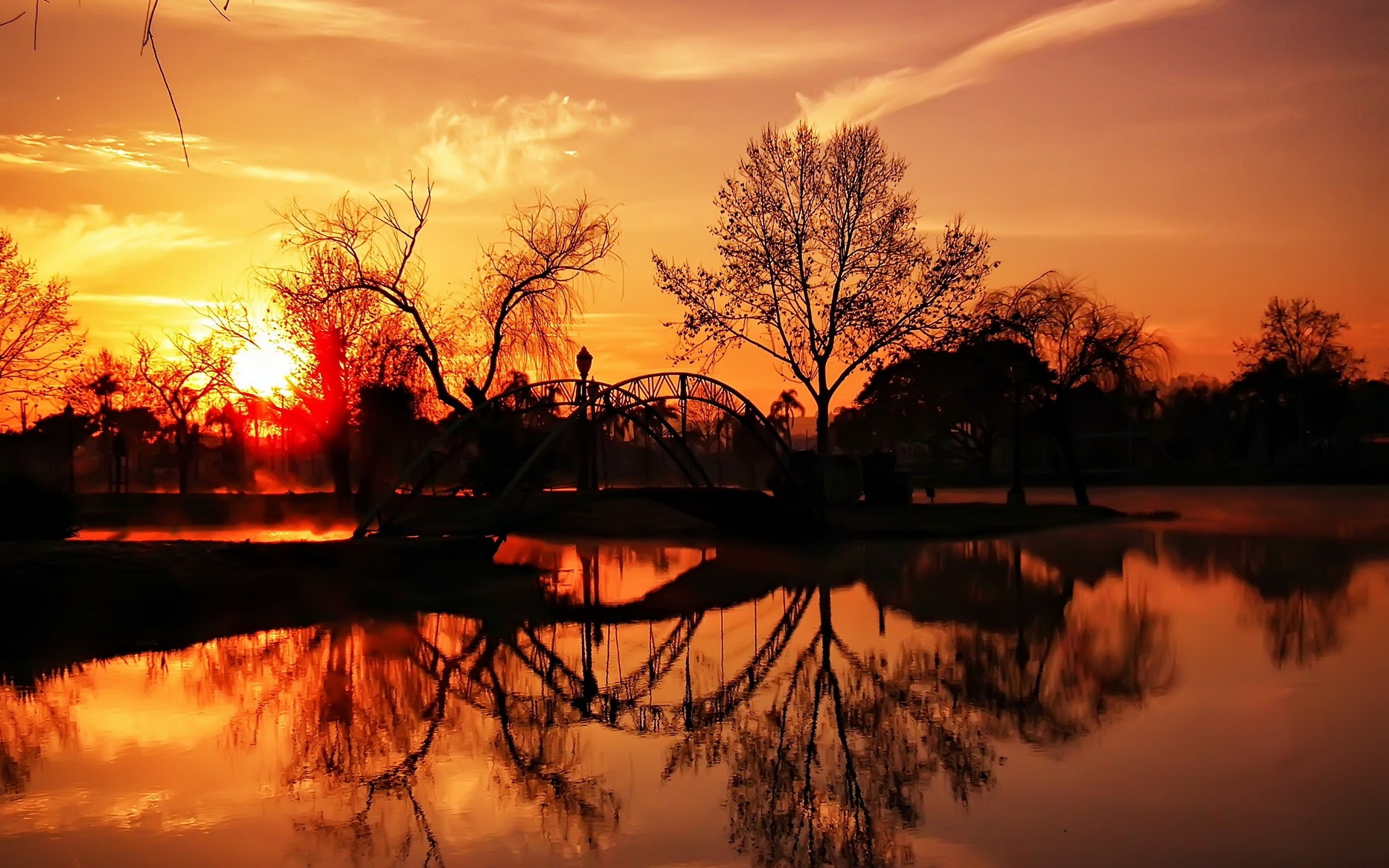 Sunset over a lake with a bridge and trees HD Wallpaper