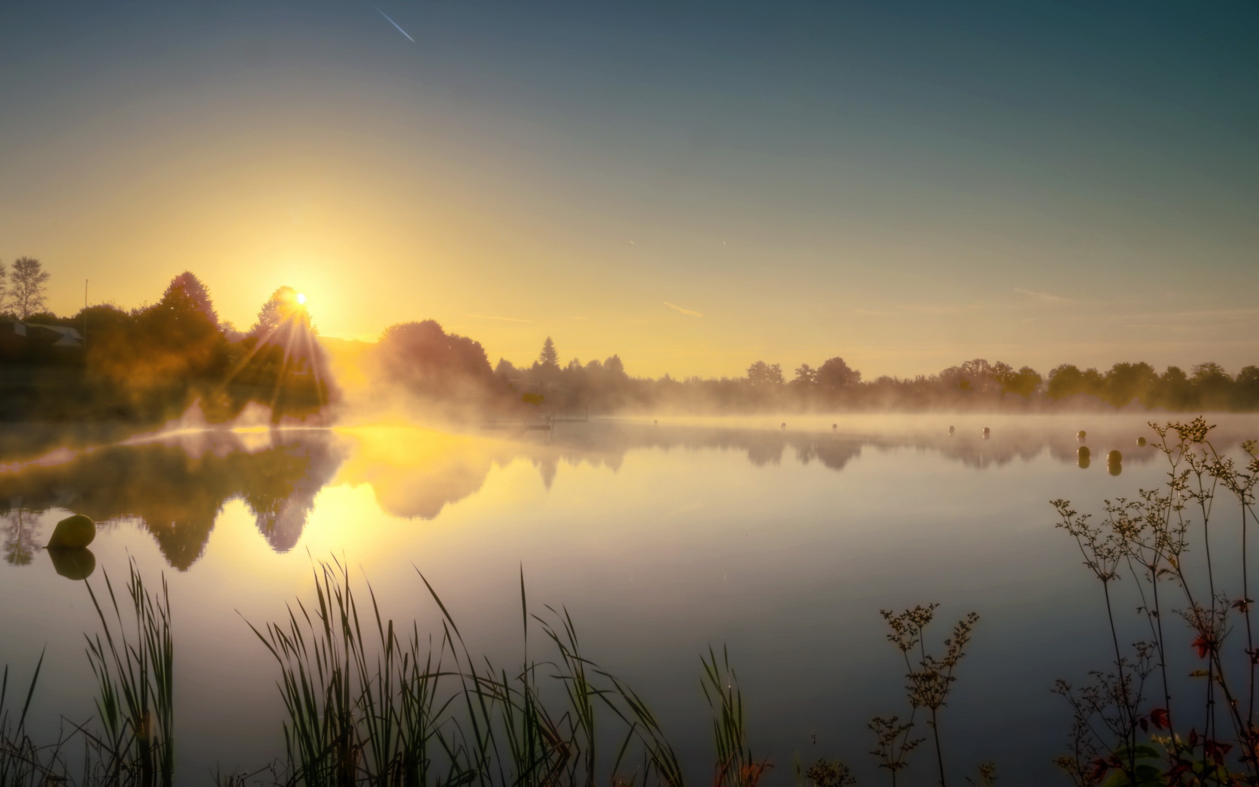 Sunrise over a misty lake with reflections HD Wallpaper